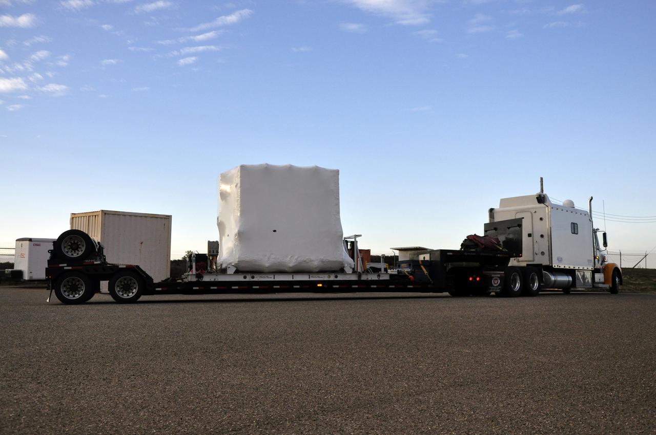 VANDENBERG AIR FORCE BASE, Calif. -- NASA's Nuclear Spectroscopic Telescope Array (NuSTAR), enclosed in an environmentally controlled shipping container, arrives at processing facility 1555 at Vandenberg Air Force Base (VAFB) in California. The spacecraft arrived at 7:52 a.m. PST after a cross-country trip from Orbital Sciences' manufacturing plant in Dulles, Va., which began Jan. 24. The spacecraft will be offloaded into the processing hangar, joining the Pegasus XL rocket that is set to carry it to space. After NuSTAR is removed from its shipping container, checkout and other processing activity will begin. The spacecraft will be integrated with the Pegasus in mid-February and encapsulation in the vehicle fairing will follow. After processing is completed, the rocket and spacecraft will be flown on Orbital's L-1011 carrier aircraft to the Ronald Reagan Ballistic Missile Defense Test Site at the Pacific Ocean's Kwajalein Atoll for launch in March. The high-energy x-ray telescope will conduct a census for black holes, map radioactive material in young supernovae remnants, and study the origins of cosmic rays and the extreme physics around collapsed stars. For more information, visit http://www.nasa.gov/nustar. Photo credit: NASA/Randy Beaudoin, VAFB