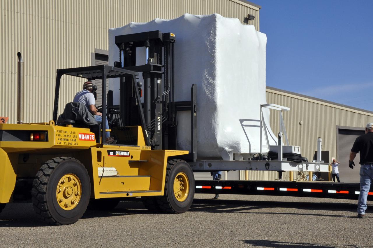 VANDENBERG AIR FORCE BASE, Calif. -- A forklift is enlisted to transfer NASA's Nuclear Spectroscopic Telescope Array (NuSTAR), enclosed in an environmentally controlled shipping container, from the tractor-trailer on which it arrived into the airlock of processing facility 1555 at Vandenberg Air Force Base (VAFB) in California. The spacecraft arrived at 7:52 a.m. PST after a cross-country trip from Orbital Sciences' manufacturing plant in Dulles, Va., which began Jan. 24. The spacecraft will be offloaded into the processing hangar, joining the Pegasus XL rocket that is set to carry it to space. After NuSTAR is removed from its shipping container, checkout and other processing activity will begin. The spacecraft will be integrated with the Pegasus in mid-February and encapsulation in the vehicle fairing will follow. After processing is completed, the rocket and spacecraft will be flown on Orbital's L-1011 carrier aircraft to the Ronald Reagan Ballistic Missile Defense Test Site at the Pacific Ocean's Kwajalein Atoll for launch in March. The high-energy x-ray telescope will conduct a census for black holes, map radioactive material in young supernovae remnants, and study the origins of cosmic rays and the extreme physics around collapsed stars. For more information, visit http://www.nasa.gov/nustar. Photo credit: NASA/Randy Beaudoin, VAFB
