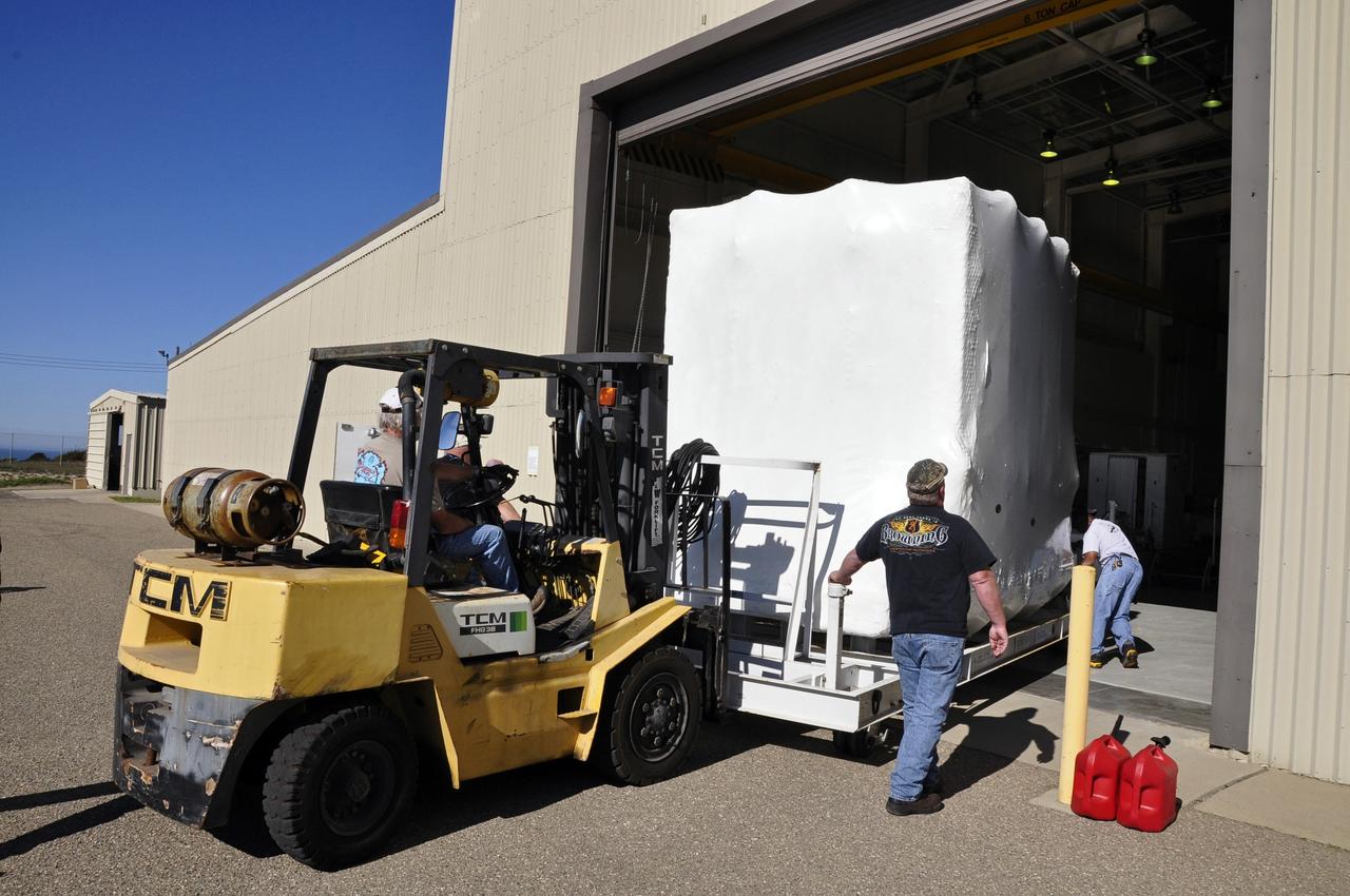VANDENBERG AIR FORCE BASE, Calif. -- Workers roll the environmentally controlled shipping container enclosing NASA's Nuclear Spectroscopic Telescope Array (NuSTAR) through the door of the airlock of processing facility 1555 at Vandenberg Air Force Base (VAFB) in California. The spacecraft arrived at 7:52 a.m. PST after a cross-country trip from Orbital Sciences' manufacturing plant in Dulles, Va., which began Jan. 24. The spacecraft will be offloaded into the processing hangar, joining the Pegasus XL rocket that is set to carry it to space. After NuSTAR is removed from its shipping container, checkout and other processing activity will begin. The spacecraft will be integrated with the Pegasus in mid-February and encapsulation in the vehicle fairing will follow. After processing is completed, the rocket and spacecraft will be flown on Orbital's L-1011 carrier aircraft to the Ronald Reagan Ballistic Missile Defense Test Site at the Pacific Ocean's Kwajalein Atoll for launch in March. The high-energy x-ray telescope will conduct a census for black holes, map radioactive material in young supernovae remnants, and study the origins of cosmic rays and the extreme physics around collapsed stars. For more information, visit http://www.nasa.gov/nustar. Photo credit: NASA/Randy Beaudoin, VAFB