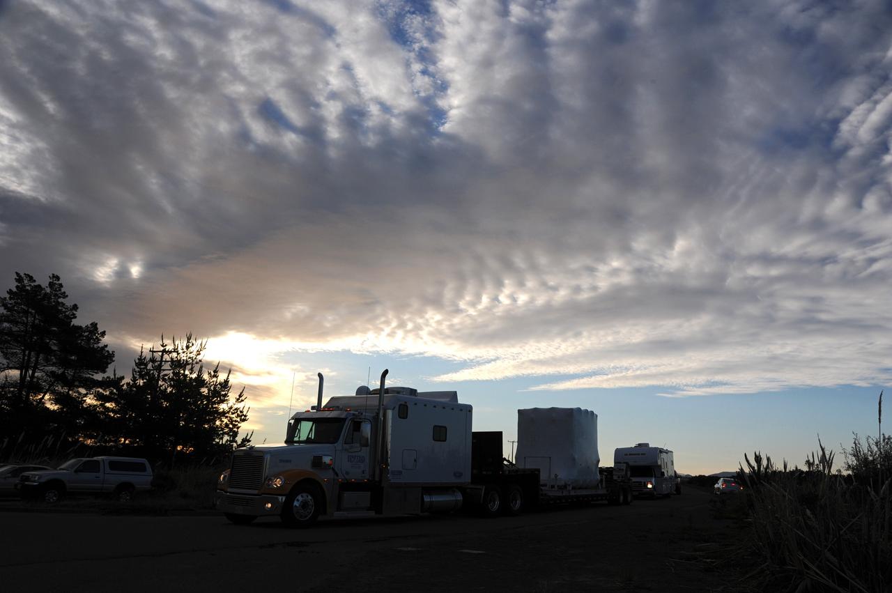VANDENBERG AIR FORCE BASE, Calif. -- A tractor-trailer delivers NASA's Nuclear Spectroscopic Telescope Array (NuSTAR), enclosed in an environmentally controlled shipping container, to processing facility 1555 at Vandenberg Air Force Base (VAFB) in California. The spacecraft arrived at 7:52 a.m. PST after a cross-country trip which began Jan. 24 from Orbital Sciences' manufacturing plant in Dulles, Va. The spacecraft will be removed from the shipping container in the airlock and transferred into the processing hangar, joining the Pegasus XL rocket that is set to carry it to space. After checkout and other processing activities are complete, the spacecraft will be integrated with the Pegasus in mid-February and encapsulation in the vehicle fairing will follow. The rocket and spacecraft then will be flown on Orbital's L-1011 carrier aircraft to the Ronald Reagan Ballistic Missile Defense Test Site at the Pacific Ocean's Kwajalein Atoll for launch in March. The high-energy x-ray telescope will conduct a census for black holes, map radioactive material in young supernovae remnants, and study the origins of cosmic rays and the extreme physics around collapsed stars. For more information, visit http://www.nasa.gov/nustar. Photo credit: NASA/Randy Beaudoin, VAFB