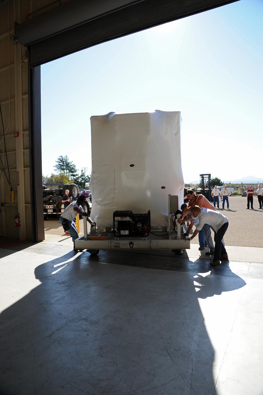 VANDENBERG AIR FORCE BASE, Calif. -- Workers roll the environmentally controlled shipping container enclosing NASA's Nuclear Spectroscopic Telescope Array (NuSTAR) through the door of the airlock of processing facility 1555 at Vandenberg Air Force Base (VAFB) in California. The spacecraft arrived at 7:52 a.m. PST after a cross-country trip which began Jan. 24 from Orbital Sciences' manufacturing plant in Dulles, Va. The spacecraft will be removed from the shipping container in the airlock and transferred into the processing hangar, joining the Pegasus XL rocket that is set to carry it to space. After checkout and other processing activities are complete, the spacecraft will be integrated with the Pegasus in mid-February and encapsulation in the vehicle fairing will follow. The rocket and spacecraft then will be flown on Orbital's L-1011 carrier aircraft to the Ronald Reagan Ballistic Missile Defense Test Site at the Pacific Ocean's Kwajalein Atoll for launch in March. The high-energy x-ray telescope will conduct a census for black holes, map radioactive material in young supernovae remnants, and study the origins of cosmic rays and the extreme physics around collapsed stars. For more information, visit http://www.nasa.gov/nustar. Photo credit: NASA/Randy Beaudoin, VAFB