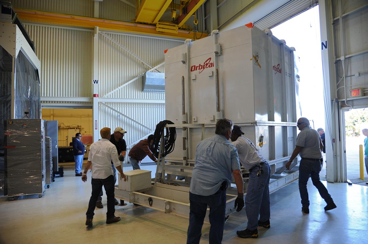 VANDENBERG AIR FORCE BASE, Calif. -- Workers maneuver the payload transporter carrying the environmentally controlled shipping container enclosing NASA's Nuclear Spectroscopic Telescope Array (NuSTAR) into position in the airlock of processing facility 1555 at Vandenberg Air Force Base (VAFB) in California. The spacecraft arrived at 7:52 a.m. PST after a cross-country trip which began Jan. 24 from Orbital Sciences' manufacturing plant in Dulles, Va. The spacecraft will be removed from the shipping container in the airlock and transferred into the processing hangar, joining the Pegasus XL rocket that is set to carry it to space. After checkout and other processing activities are complete, the spacecraft will be integrated with the Pegasus in mid-February and encapsulation in the vehicle fairing will follow. The rocket and spacecraft then will be flown on Orbital's L-1011 carrier aircraft to the Ronald Reagan Ballistic Missile Defense Test Site at the Pacific Ocean's Kwajalein Atoll for launch in March. The high-energy x-ray telescope will conduct a census for black holes, map radioactive material in young supernovae remnants, and study the origins of cosmic rays and the extreme physics around collapsed stars. For more information, visit http://www.nasa.gov/nustar. Photo credit: NASA/Randy Beaudoin, VAFB