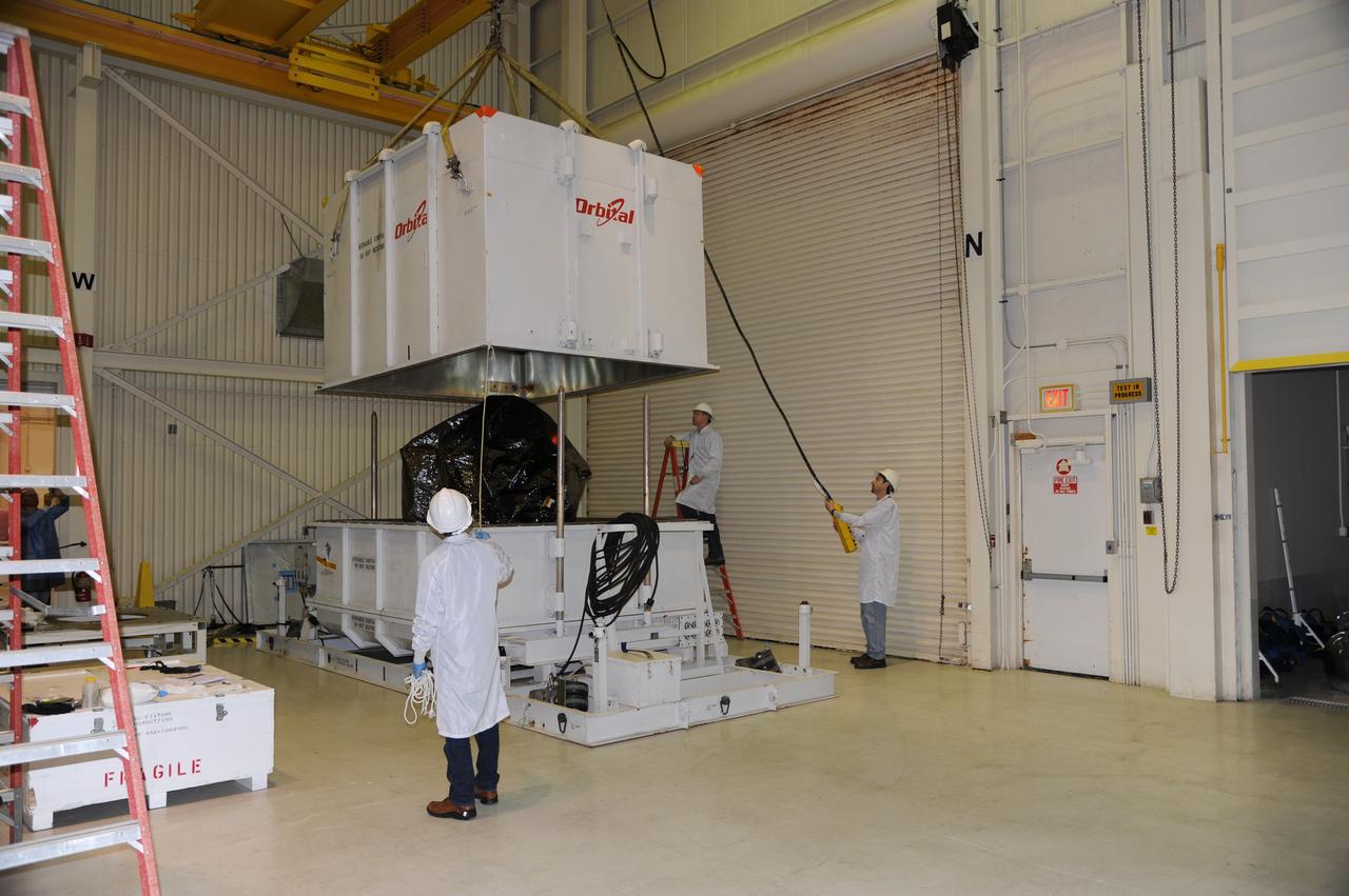 VANDENBERG AIR FORCE BASE, Calif. -- In the airlock of processing facility 1555 at Vandenberg Air Force Base (VAFB) in California, workers lift the top half of the shipping container from around NASA's Nuclear Spectroscopic Telescope Array (NuSTAR), wrapped in a protective shroud. The spacecraft arrived at VAFB Jan. 27 after a cross-country trip which began from Orbital Sciences' manufacturing plant in Dulles, Va., on Jan. 24. Next, NuSTAR will be transferred from the airlock into the processing hangar, joining the Pegasus XL rocket that is set to carry it to space. After checkout and other processing activities are complete, the spacecraft will be integrated with the Pegasus in mid-February and encapsulation in the vehicle fairing will follow. The rocket and spacecraft then will be flown on Orbital's L-1011 carrier aircraft to the Ronald Reagan Ballistic Missile Defense Test Site at the Pacific Ocean's Kwajalein Atoll for launch in March. The high-energy X-ray telescope will conduct a census for black holes, map radioactive material in young supernovae remnants, and study the origins of cosmic rays and the extreme physics around collapsed stars. For more information, visit http://www.nasa.gov/nustar. Photo credit: NASA/Randy Beaudoin, VAFB