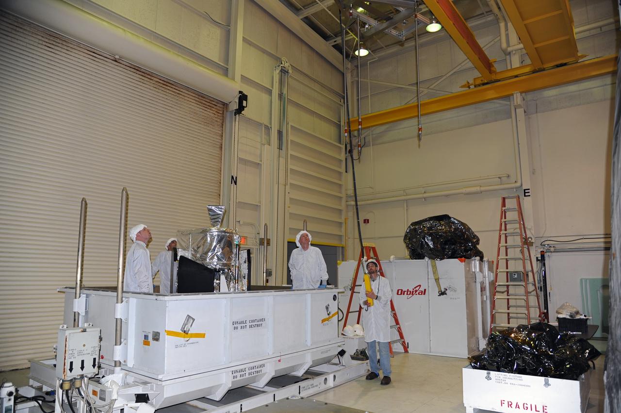 VANDENBERG AIR FORCE BASE, Calif. -- In the airlock of processing facility 1555 at Vandenberg Air Force Base (VAFB) in California, workers position a lifting fixture toward NASA's Nuclear Spectroscopic Telescope Array (NuSTAR) during preparations to hoist it from its shipping container. The spacecraft arrived at VAFB Jan. 27 after a cross-country trip which began from Orbital Sciences' manufacturing plant in Dulles, Va., on Jan. 24. Next, NuSTAR will be transferred from the airlock into the processing hangar, joining the Pegasus XL rocket that is set to carry it to space. After checkout and other processing activities are complete, the spacecraft will be integrated with the Pegasus in mid-February and encapsulation in the vehicle fairing will follow. The rocket and spacecraft then will be flown on Orbital's L-1011 carrier aircraft to the Ronald Reagan Ballistic Missile Defense Test Site at the Pacific Ocean's Kwajalein Atoll for launch in March. The high-energy X-ray telescope will conduct a census for black holes, map radioactive material in young supernovae remnants, and study the origins of cosmic rays and the extreme physics around collapsed stars. For more information, visit http://www.nasa.gov/nustar. Photo credit: NASA/Randy Beaudoin, VAFB