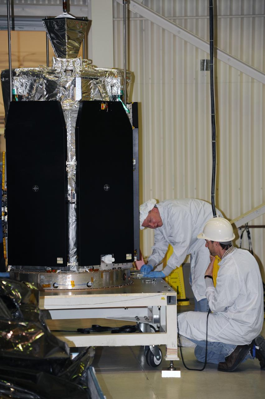 VANDENBERG AIR FORCE BASE, Calif. -- In the airlock of processing facility 1555 at Vandenberg Air Force Base (VAFB) in California, workers secure NASA's Nuclear Spectroscopic Telescope Array (NuSTAR) onto a handling dolly. The spacecraft arrived at VAFB Jan. 27 after a cross-country trip which began from Orbital Sciences' manufacturing plant in Dulles, Va., on Jan. 24. Next, NuSTAR will be transferred from the airlock into the processing hangar, joining the Pegasus XL rocket that is set to carry it to space. After checkout and other processing activities are complete, the spacecraft will be integrated with the Pegasus in mid-February and encapsulation in the vehicle fairing will follow. The rocket and spacecraft then will be flown on Orbital's L-1011 carrier aircraft to the Ronald Reagan Ballistic Missile Defense Test Site at the Pacific Ocean's Kwajalein Atoll for launch in March. The high-energy X-ray telescope will conduct a census for black holes, map radioactive material in young supernovae remnants, and study the origins of cosmic rays and the extreme physics around collapsed stars. For more information, visit http://www.nasa.gov/nustar. Photo credit: NASA/Randy Beaudoin, VAFB