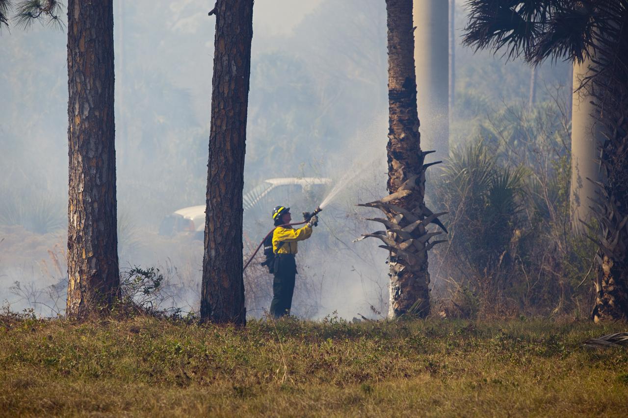 CAPE CANAVERAL, Fla. -- A firefighter manages the progress of a controlled burn in the vicinity of the Industrial Area at NASA's Kennedy Space Center in Florida.    The burn, managed by the U.S. Fish and Wildlife Service, targeted 2,174 acres near Kennedy's administrative complex. Shifting winds caused the fire to flare up in places to dramatic effect. Limited visibility caused by the smoke required NASA Security to close some roadways. The burn, which began during the 8 o'clock hour this morning, is expected to be extinguished this evening. Controlled burns are commonplace on the center to reduce the likelihood of an unplanned brush fire during Central Florida's dry season. Photo Credit: NASA/Dimitri Gerondidakis