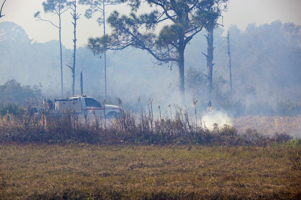 CAPE CANAVERAL, Fla. -- A firefighter mans his post at the edge of a controlled burn in the vicinity of the Industrial Area at NASA's Kennedy Space Center in Florida.    The burn, managed by the U.S. Fish and Wildlife Service, targeted 2,174 acres near Kennedy's administrative complex. Shifting winds caused the fire to flare up in places to dramatic effect. Limited visibility caused by the smoke required NASA Security to close some roadways. The burn, which began during the 8 o'clock hour this morning, is expected to be extinguished this evening. Controlled burns are commonplace on the center to reduce the likelihood of an unplanned brush fire during Central Florida's dry season. Photo Credit: NASA/Dimitri Gerondidakis