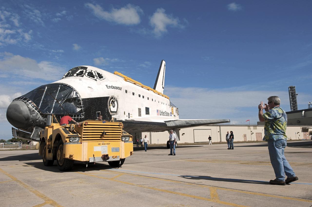 CAPE CANAVERAL, Fla. – At NASA’s Kennedy Space Center in Florida, technicians assist as space shuttle Endeavour is being towed from the Vehicle Assembly Building to Orbiter Processing Facility-2 (OPF-2). Shuttle Endeavour will remain in OPF-2 so that the orbiter maneuvering system (OMS) pods and forward reaction control system can be installed. Technicians also will offload water and Freon gas from lines located in Endeavour’s midbody. The work is part of Endeavour’s transition and retirement processing. The spacecraft is being prepared for public display at the California Science Center in Los Angeles. Endeavour flew 25 missions, spent 299 days in space, orbited Earth 4,671 times and traveled 122, 883, 151 miles over the course of its 19-year career. Endeavour’s STS-134 and final mission was completed after landing on June 1, 2011. Photo credit: Kim Shiflett