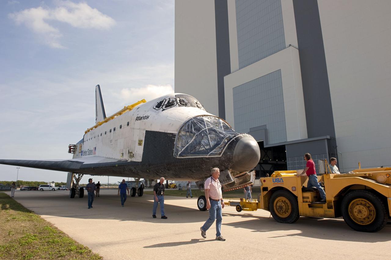 CAPE CANAVERAL, Fla. – At NASA’s Kennedy Space Center in Florida, technicians walk alongside space shuttle Atlantis as it is towed from the Vehicle Assembly Building (VAB) transfer aisle on its way around to the VAB high bay 4 doors.    Shuttle Atlantis will remain in temporary storage in high bay 4, while Space Shuttle Program transition and retirement work continues on Discovery and Endeavour in the orbiter processing facilities. Atlantis is being prepared for display at the Kennedy Space Center Visitor Complex.  Photo credit: NASA/Kim Shiflett