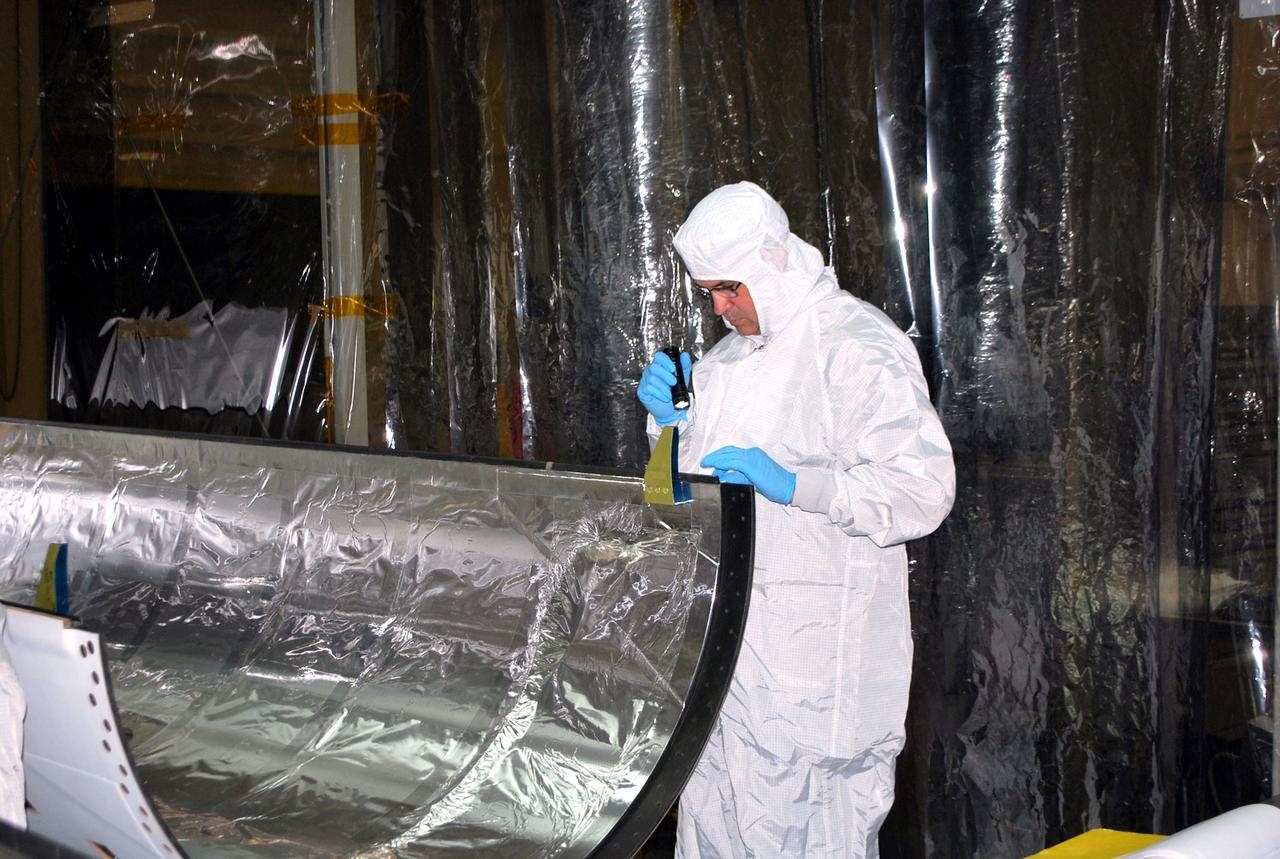 VANDENBERG AIR FORCE BASE, Calif. – In an environmental enclosure in processing facility 1555 at Vandenberg Air Force Base in California, a spacecraft technician inspects half of a Pegasus payload fairing for NASA's Nuclear Spectroscopic Telescope Array (NuSTAR) mission. The fairing will protect the spacecraft from the heat and aerodynamic pressure generated during ascent to orbit aboard an Orbital Sciences Pegasus XL rocket in March. Once processing of the rocket and spacecraft are completed at Vandenberg, they will be flown aboard an L-1011 carrier aircraft to the Ronald Reagan Ballistic Missile Defense Test Site on the Pacific Ocean’s Kwajalein Atoll for launch. NuSTAR, a high-energy x-ray telescope, will conduct a census for black holes, map radioactive material in young supernovae remnants, and study the origins of cosmic rays and the extreme physics around collapsed stars. For more information, visit http://www.nasa.gov/nustar. Photo credit: NASA/Randy Beaudoin, VAFB