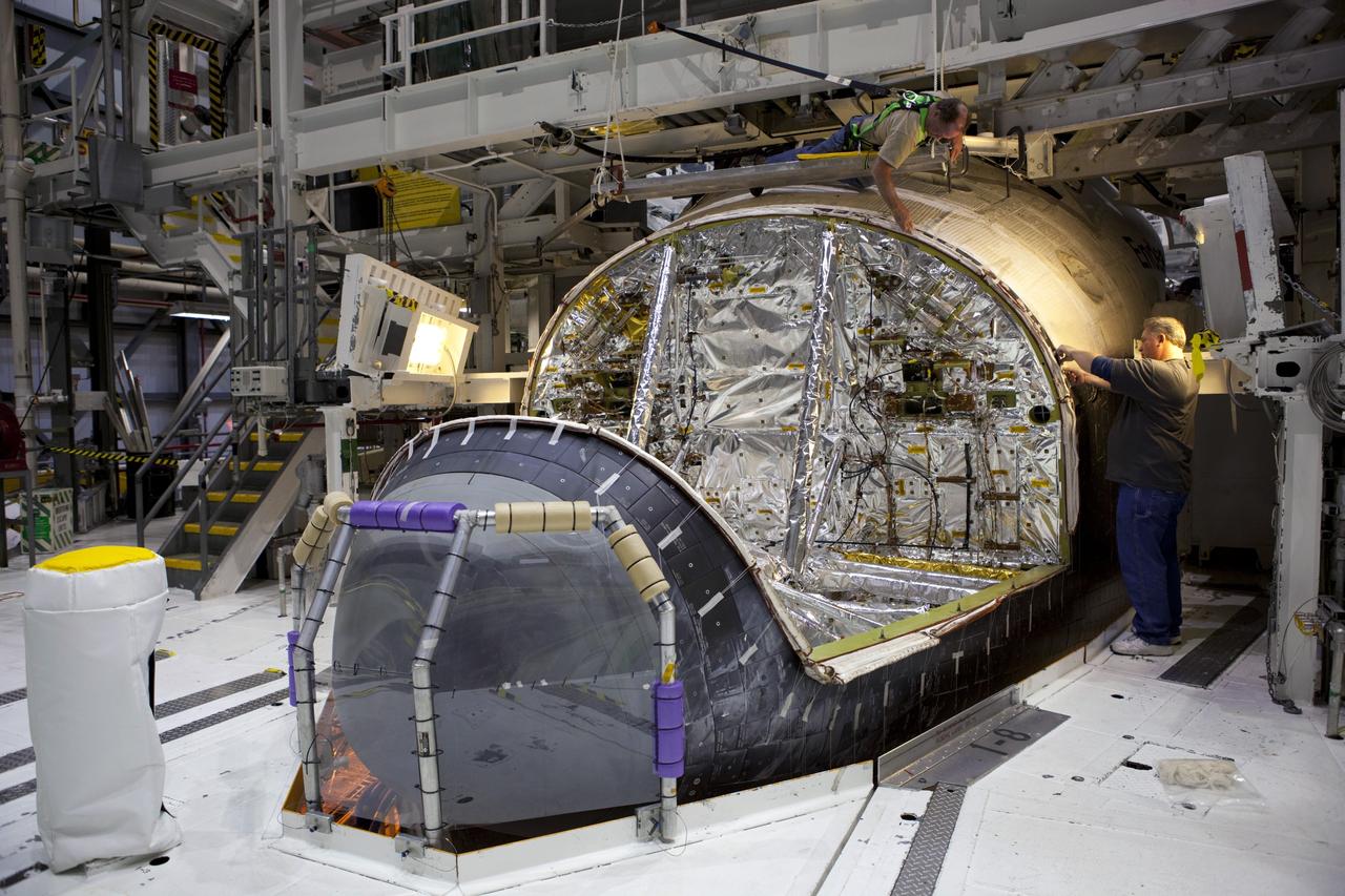 CAPE CANAVERAL, Fla. – In Orbiter Processing Facility-2 at NASA’s Kennedy Space Center in Florida, technicians prepare space shuttle Endeavour so that the forward reaction control system (FRCS) can be lifted and installed. The work is part of the Space Shuttle Program transition and retirement processing of Endeavour. The FRCS helped maneuver a shuttle while it was in orbit. The FRCS was removed from Endeavour and sent to White Sands Test Facility in N.M. to be cleaned of its toxic propellants. Endeavour is being prepared for display at the California Science Center in Los Angeles. Photo credit: NASA/Dimitri Gerondidakis
