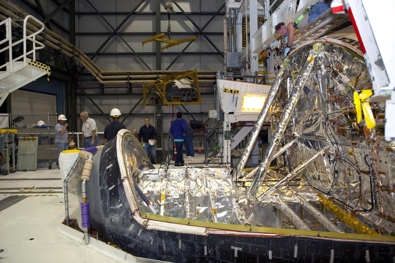CAPE CANAVERAL, Fla. – In Orbiter Processing Facility-2 at NASA’s Kennedy Space Center in Florida, technicians monitor the progress as a large crane lifts and moves the forward reaction control system (FRCS) for installation on space shuttle Endeavour. The work is part of the Space Shuttle Program transition and retirement processing of Endeavour. The FRCS helped maneuver a shuttle while it was in orbit. The FRCS was removed from Endeavour and sent to White Sands Test Facility in N.M. to be cleaned of its toxic propellants. Endeavour is being prepared for display at the California Science Center in Los Angeles. Photo credit: NASA/Dimitri Gerondidakis