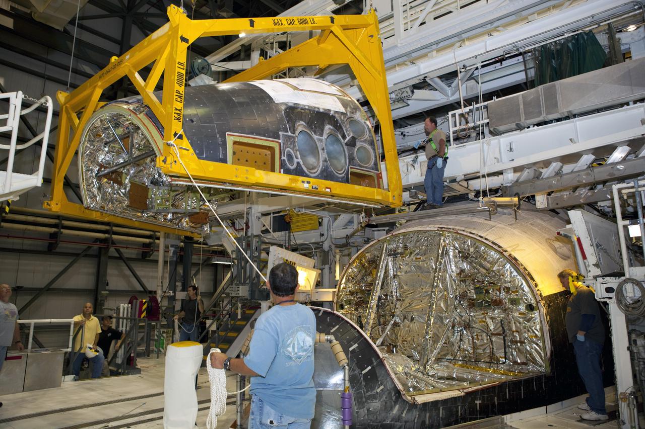 CAPE CANAVERAL, Fla. – In Orbiter Processing Facility-2 at NASA’s Kennedy Space Center in Florida, technicians monitor the progress as a large crane lifts and moves the forward reaction control system (FRCS) closer for installation on space shuttle Endeavour. The work is part of the Space Shuttle Program transition and retirement processing of Endeavour. The FRCS helped maneuver a shuttle while it was in orbit. The FRCS was removed from Endeavour and sent to White Sands Test Facility in N.M. to be cleaned of its toxic propellants. Endeavour is being prepared for display at the California Science Center in Los Angeles. Photo credit: NASA/Dimitri Gerondidakis