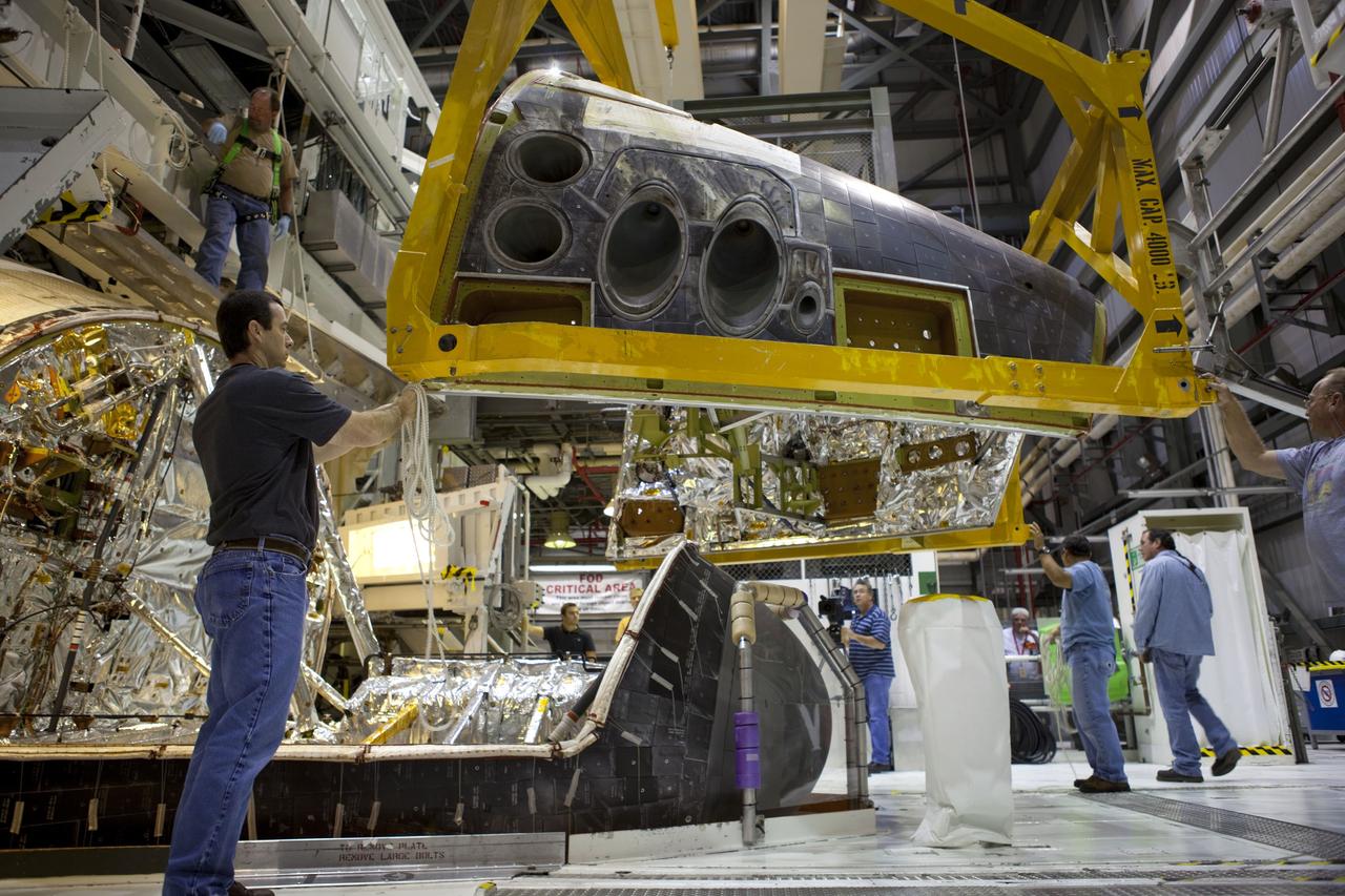 CAPE CANAVERAL, Fla. – In Orbiter Processing Facility-2 at NASA’s Kennedy Space Center in Florida, technicians assist as a large crane lowers the forward reaction control system (FRCS) for installation on space shuttle Endeavour. The work is part of the Space Shuttle Program transition and retirement processing of Endeavour. The FRCS helped maneuver a shuttle while it was in orbit. The FRCS was removed from Endeavour and sent to White Sands Test Facility in N.M. to be cleaned of its toxic propellants. Endeavour is being prepared for display at the California Science Center in Los Angeles. Photo credit: NASA/Dimitri Gerondidakis