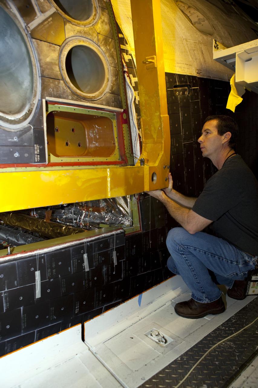 CAPE CANAVERAL, Fla. – In Orbiter Processing Facility-2 at NASA’s Kennedy Space Center in Florida, a technician helps guide a large crane as it lowers the forward reaction control system (FRCS) for installation on space shuttle Endeavour. The work is part of the Space Shuttle Program transition and retirement processing of Endeavour. The FRCS helped maneuver a shuttle while it was in orbit. The FRCS was removed from Endeavour and sent to White Sands Test Facility in N.M. to be cleaned of its toxic propellants. Endeavour is being prepared for display at the California Science Center in Los Angeles. Photo credit: NASA/Dimitri Gerondidakis