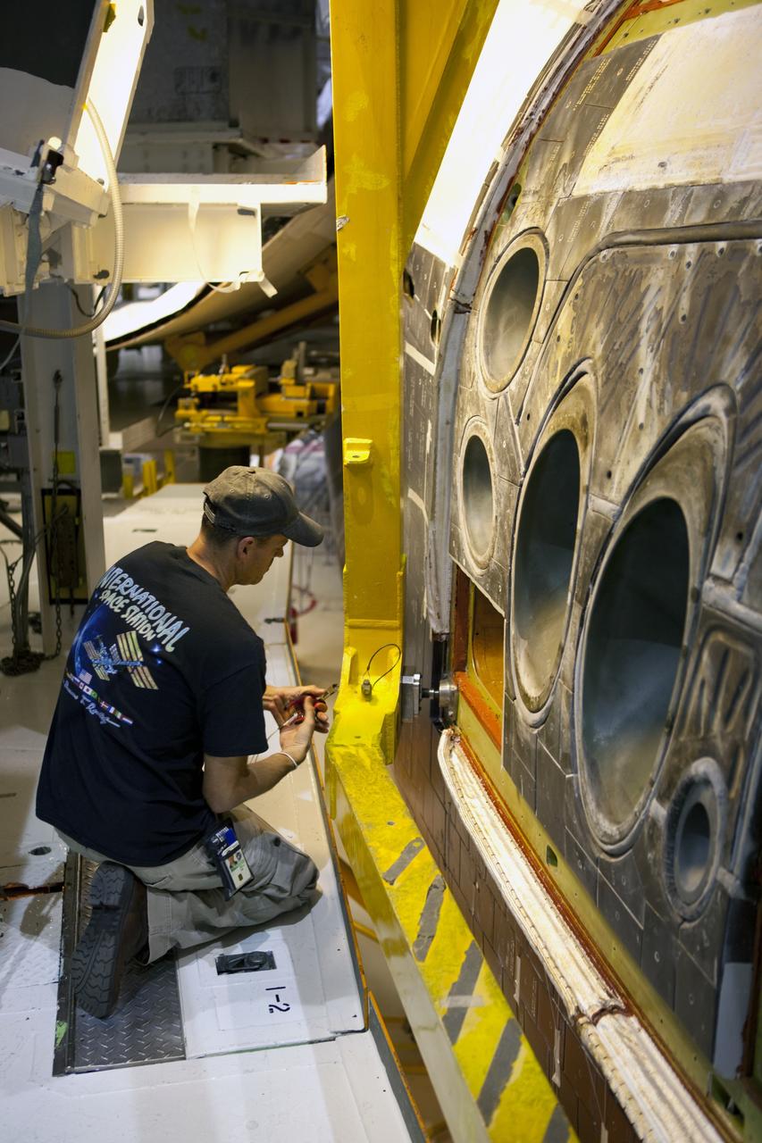 CAPE CANAVERAL, Fla. – In Orbiter Processing Facility-2 at NASA’s Kennedy Space Center in Florida, a technician assists as a large crane lowers the forward reaction control system (FRCS) for installation on space shuttle Endeavour. The work is part of the Space Shuttle Program transition and retirement processing of Endeavour. The FRCS helped maneuver a shuttle while it was in orbit. The FRCS was removed from Endeavour and sent to White Sands Test Facility in N.M. to be cleaned of its toxic propellants. Endeavour is being prepared for display at the California Science Center in Los Angeles. Photo credit: NASA/Dimitri Gerondidakis