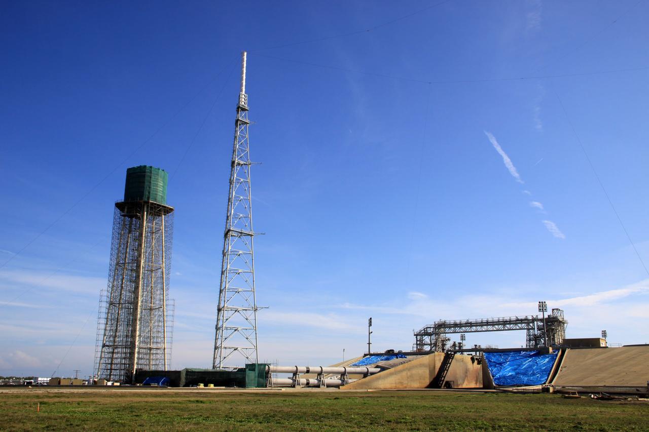 CAPE CANAVERAL, Fla. - At NASA’s Kennedy Space Center in Florida, preparations are underway to sandblast and paint the 290-foot-high water tower at Launch Pad 39B. Scaffolding surrounds the tower and a special covering has been placed around the tank.    The water towers at Launch Complex 39, which includes pad A and B, were part of the sound suppression system used during space shuttle launches. Water stored in the 300,000-gallon tank would be released just prior to main engine ignition and flow by gravity to special mobile launcher platform (MLP) outlets. Nine seconds after shuttle liftoff, the peak flow rate was 900,000 gallons per minute and helped to protect the orbiter and payloads from being damaged by acoustical energy reflected from the MLP during liftoff. Photo Credit: NASA/Jim Grossmann