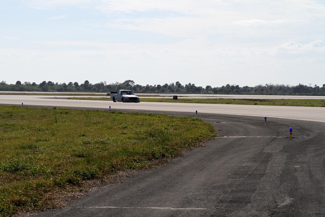 CAPE CANAVERAL, Fla. - At NASA’s Kennedy Space Center in Florida, NASCAR racer Jason Leffler with Kyle Busch Motorsports (KBM) drives his instrument-laden vehicle back from the three-mile-long drive down the Shuttle Landing Facility runway. The operation is part of KBMs’ program to test aerodynamic and real-world capabilities on one of the flattest surfaces in the world.    Racing teams have been using the runway for testing since 2008. KBM signed a Space Act Agreement with NASA to use the facility’s runway. Photo Credit: NASA/Kim Shiflett