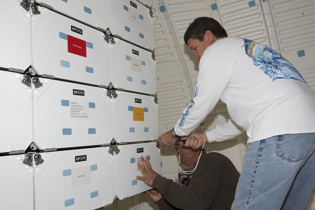 CAPE CANAVERAL, Fla. -- Inside Orbiter Processing Facility-1 at NASA’s Kennedy Space Center in Florida, technicians reinstall the lockers in the middeck of space shuttle Discovery.    The work is part of the Space Shuttle Program’s transition and retirement processing of shuttle Discovery, which is being prepared for display at Smithsonian’s National Air and Space Museum, Steven F. Udvar-Hazy Center in Chantilly, Va. Discovery is scheduled to be transported atop a NASA Shuttle Carrier Aircraft modified 747 jet to Dulles International Airport in Virginia on April 17 and then be transported to the Smithsonian on April 19. For more information, visit http://www.nasa.gov/shuttle.  Photo credit: NASA/Jim Grossmann