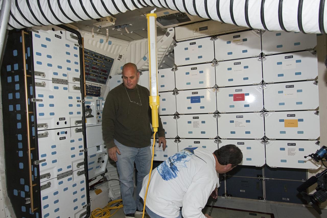 CAPE CANAVERAL, Fla. -- Inside Orbiter Processing Facility-1 at NASA’s Kennedy Space Center in Florida, technicians reinstall the lockers in the middeck of space shuttle Discovery.    The work is part of the Space Shuttle Program’s transition and retirement processing of shuttle Discovery, which is being prepared for display at Smithsonian’s National Air and Space Museum, Steven F. Udvar-Hazy Center in Chantilly, Va. Discovery is scheduled to be transported atop a NASA Shuttle Carrier Aircraft modified 747 jet to Dulles International Airport in Virginia on April 17 and then be transported to the Smithsonian on April 19. For more information, visit http://www.nasa.gov/shuttle.  Photo credit: NASA/Jim Grossmann