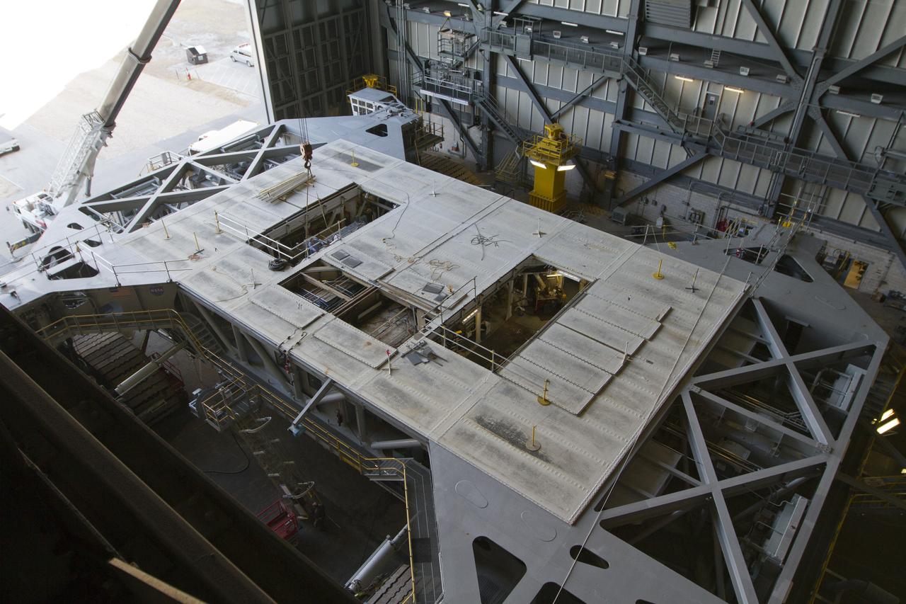 CAPE CANAVERAL, Fla. –Inside the Vehicle Assembly Building at NASA’s Kennedy Space Center in Florida, a crane is lowered toward crawler-transporter 2 CT-2) so that the Apollo era diesel engine can be removed. New engines will be installed later this month. Work is in progress in high bay 2 to upgrade CT-2 so that it can carry NASA’s Space Launch System heavy-lift rocket, which is under design, and new Orion spacecraft to the launch pad. The crawler-transporters were used to carry the mobile launcher platform and space shuttle to Launch Complex 39 for space shuttle launches for 30 years. Photo credit: NASA/Kim Shiflett