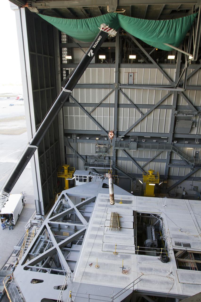 CAPE CANAVERAL, Fla. –– Inside the Vehicle Assembly Building at NASA’s Kennedy Space Center in Florida, a crane lifts part of an Apollo era diesel engine from crawler-transporter 2 CT-2). New engines will be installed later this month. Work is in progress in high bay 2 to upgrade CT-2 so that it can carry NASA’s Space Launch System heavy-lift rocket, which is under design, and new Orion spacecraft to the launch pad. The crawler-transporters were used to carry the mobile launcher platform and space shuttle to Launch Complex 39 for space shuttle launches for 30 years. Photo credit: NASA/Kim Shiflett