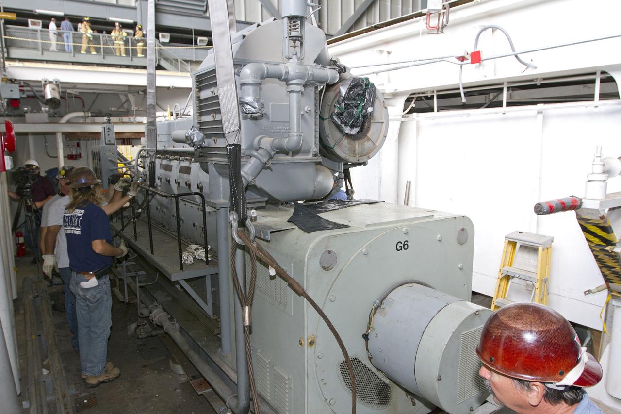 CAPE CANAVERAL, Fla. –– Inside the Vehicle Assembly Building at NASA’s Kennedy Space Center in Florida, technicians prepare an Apollo era diesel engine inside crawler-transporter 2 CT-2) for removal. New engines will be installed later this month. Work is in progress in high bay 2 to upgrade CT-2 so that it can carry NASA’s Space Launch System heavy-lift rocket, which is under design, and new Orion spacecraft to the launch pad. The crawler-transporters were used to carry the mobile launcher platform and space shuttle to Launch Complex 39 for space shuttle launches for 30 years. Photo credit: NASA/Kim Shiflett