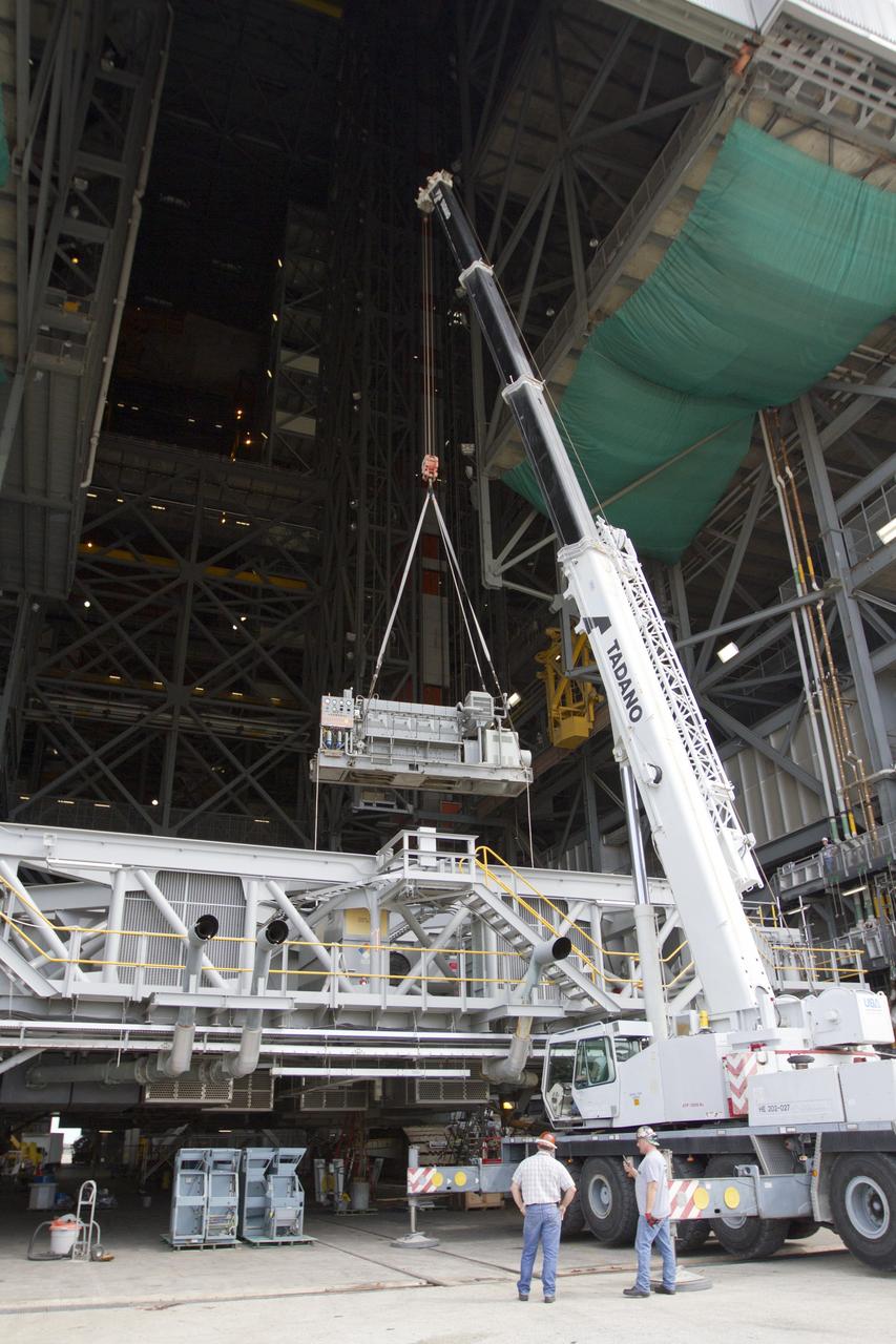 CAPE CANAVERAL, Fla. –– Inside the Vehicle Assembly Building at NASA’s Kennedy Space Center in Florida, a crane is used to lift an Apollo era diesel engine away from crawler-transporter 2 CT-2). New engines will be installed later this month. Work is in progress in high bay 2 to upgrade CT-2 so that it can carry NASA’s Space Launch System heavy-lift rocket, which is under design, and new Orion spacecraft to the launch pad. The crawler-transporters were used to carry the mobile launcher platform and space shuttle to Launch Complex 39 for space shuttle launches for 30 years. Photo credit: NASA/Kim Shiflett