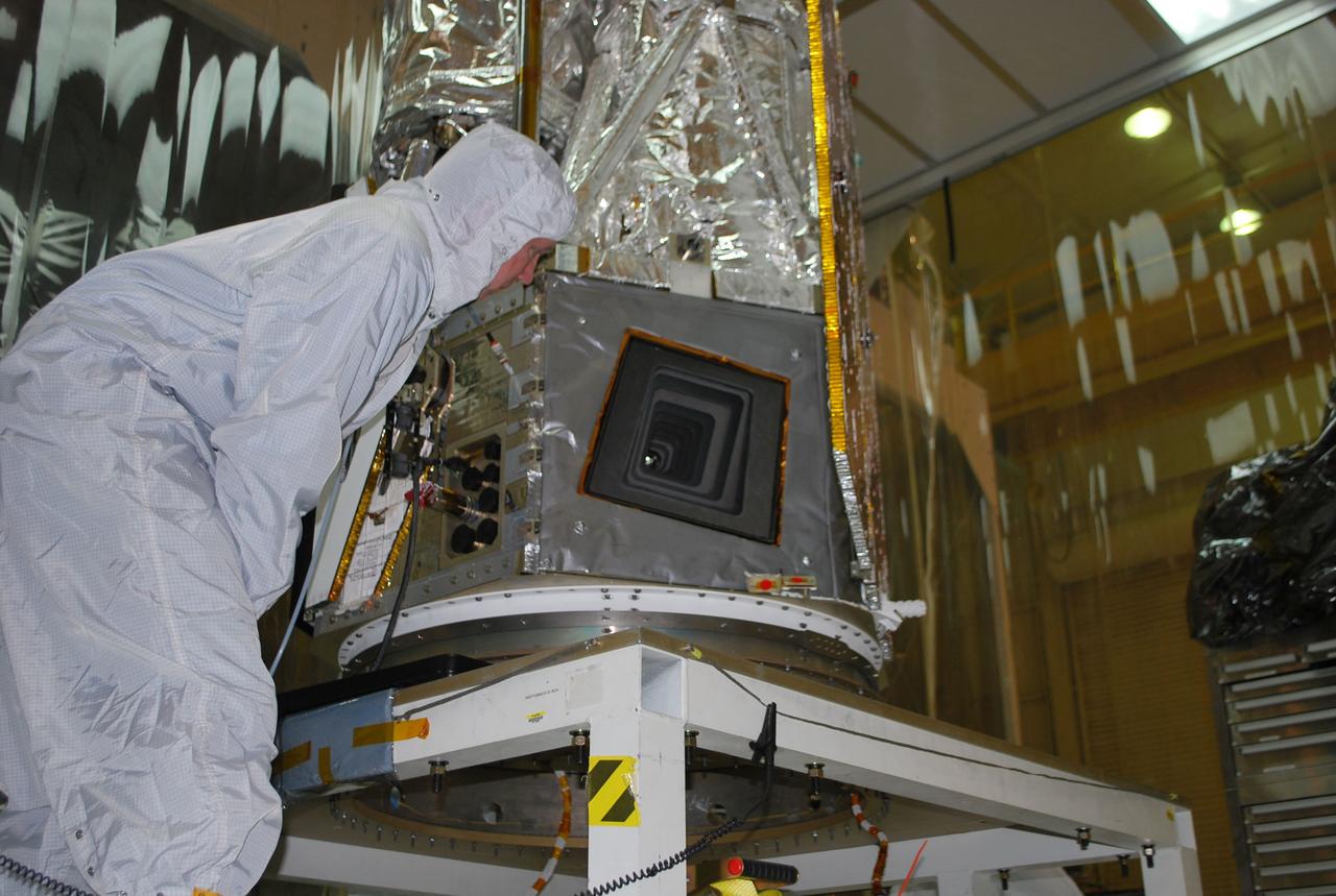 VANDENBERG AIR FORCE BASE, Calif. -- As a technician monitors the solar array deployment test at Vandenberg Air Force Base's processing facility in California, NuSTAR’s X-ray telescope is visible.       The Pegasus will launch NASA's Nuclear Spectroscopic Telescope Array NuSTAR into space. After the rocket and spacecraft are processed at Vandenberg, they will be flown on the Orbital Sciences’ L-1011 carrier aircraft to the Ronald Reagan Ballistic Missile Defense Test Site at the Pacific Ocean’s Kwajalein Atoll for launch. The high-energy x-ray telescope will conduct a census for black holes, map radioactive material in young supernovae remnants, and study the origins of cosmic rays and the extreme physics around collapsed stars. For more information, visit science.nasa.gov/missions/nustar/. Photo credit: NASA/Randy Beaudoin, VAFB