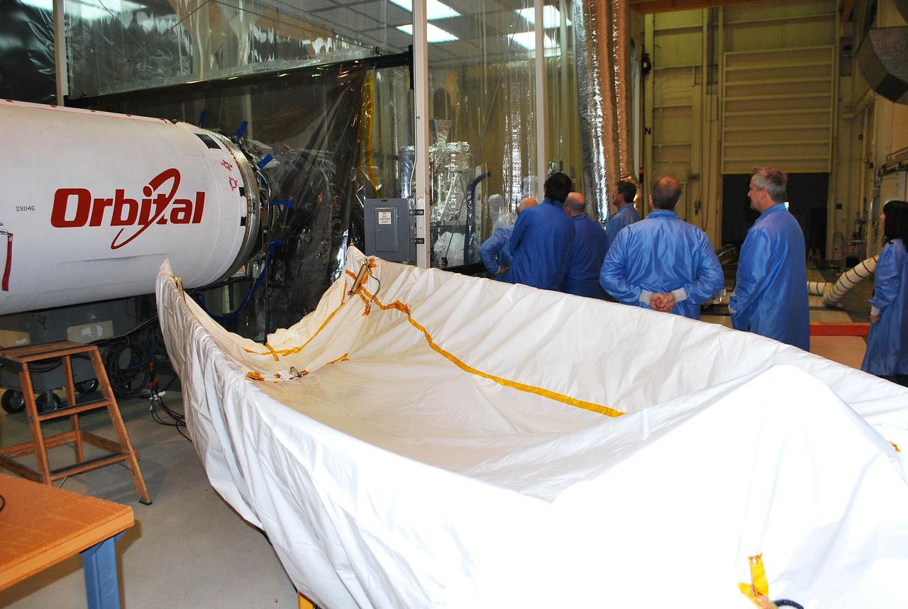 VANDENBERG AIR FORCE BASE, Calif. -- With the Pegasus XL rocket and fairing inside Orbital Science's processing facility at Vandenberg Air Force Base in California, technicians watch the NuSTAR solar array test from inside a clean room environmental enclosure. The Pegasus will launch NASA's Nuclear Spectroscopic Telescope Array NuSTAR into space. After the rocket and spacecraft are processed at Vandenberg, they will be flown on the Orbital Sciences’ L-1011 carrier aircraft to the Ronald Reagan Ballistic Missile Defense Test Site at the Pacific Ocean’s Kwajalein Atoll for launch. The high-energy x-ray telescope will conduct a census for black holes, map radioactive material in young supernovae remnants, and study the origins of cosmic rays and the extreme physics around collapsed stars. For more information, visit science.nasa.gov/missions/nustar/. Photo credit: NASA/Randy Beaudoin, VAFB