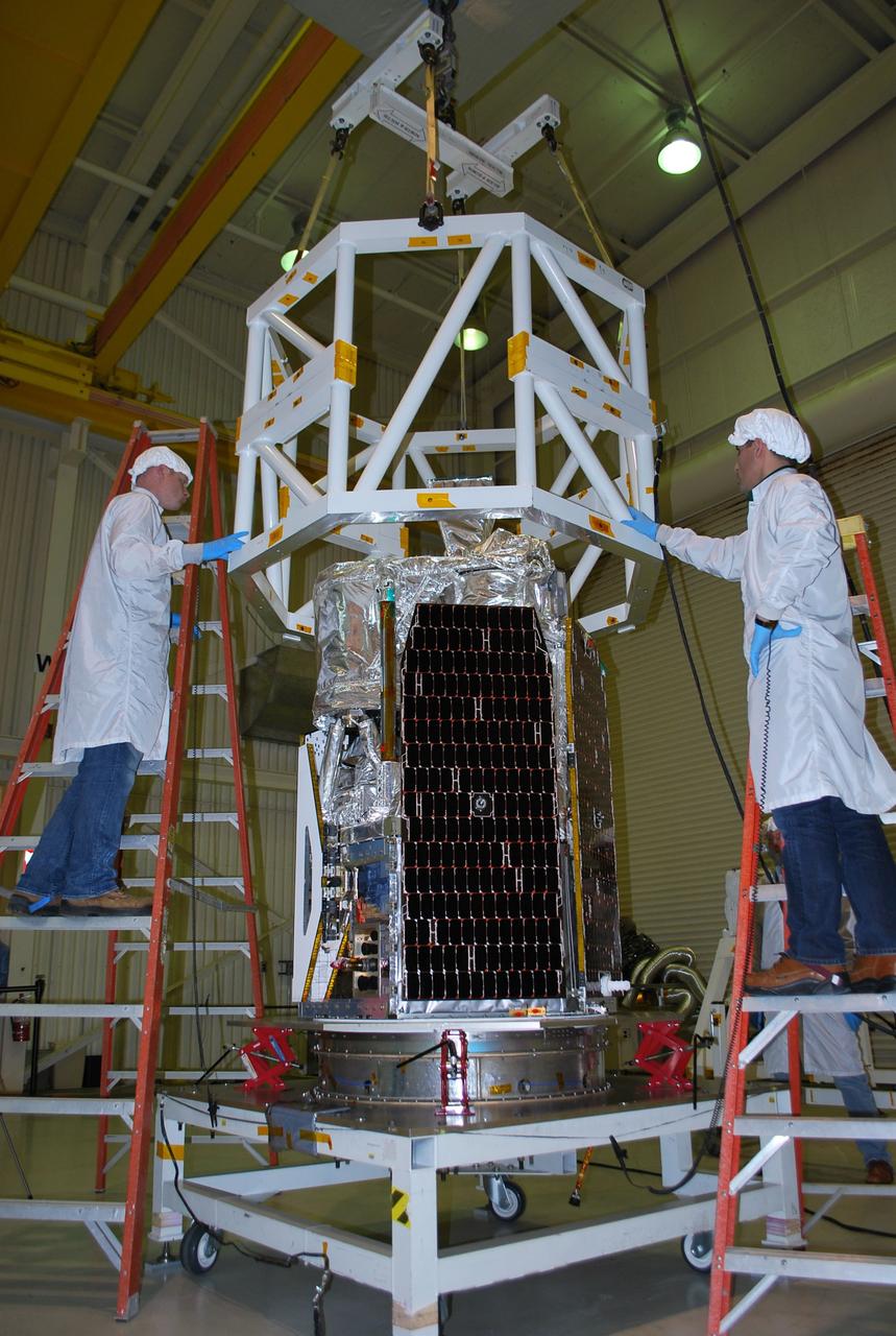 VANDENBERG AIR FORCE BASE, Calif. -- Technicians carefully guide the tilt-rotation fixture as it is lowered toward NASA's NuSTAR spacecraft inside Orbital Sciences' processing facility at Vandenberg Air Force Base, Calif. The spacecraft will be rotated to horizontal for joining with the Pegasus XL rocket. The Orbital Sciences Pegasus will launch NASA's Nuclear Spectroscopic Telescope Array NuSTAR into space. After the rocket and spacecraft are processed at Vandenberg, they will be flown on Orbital's L-1011 carrier aircraft to the Ronald Reagan Ballistic Missile Defense Test Site at the Pacific Ocean’s Kwajalein Atoll for launch. The high-energy x-ray telescope will conduct a census for black holes, map radioactive material in young supernovae remnants, and study the origins of cosmic rays and the extreme physics around collapsed stars. For more information, visit science.nasa.gov/missions/nustar/. Photo credit: NASA/Randy Beaudoin, VAFB