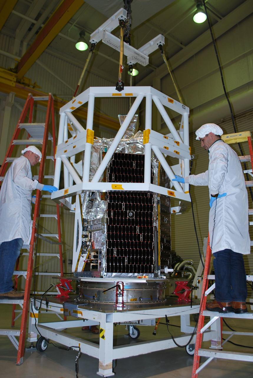 VANDENBERG AIR FORCE BASE, Calif. -- Inside Orbital Sciences' processing facility at Vandenberg Air Force Base in California, technicians guide a lifting device into place around NASA's NuSTAR spacecraft. The spacecraft will be rotated to horizontal for joining with the Pegasus XL rocket. The Orbital Sciences Pegasus will launch NASA's Nuclear Spectroscopic Telescope Array NuSTAR into space. After the rocket and spacecraft are processed at Vandenberg, they will be flown on Orbital's L-1011 carrier aircraft to the Ronald Reagan Ballistic Missile Defense Test Site at the Pacific Ocean’s Kwajalein Atoll for launch. The high-energy x-ray telescope will conduct a census for black holes, map radioactive material in young supernovae remnants, and study the origins of cosmic rays and the extreme physics around collapsed stars. For more information, visit science.nasa.gov/missions/nustar/. Photo credit: NASA/Randy Beaudoin, VAFB
