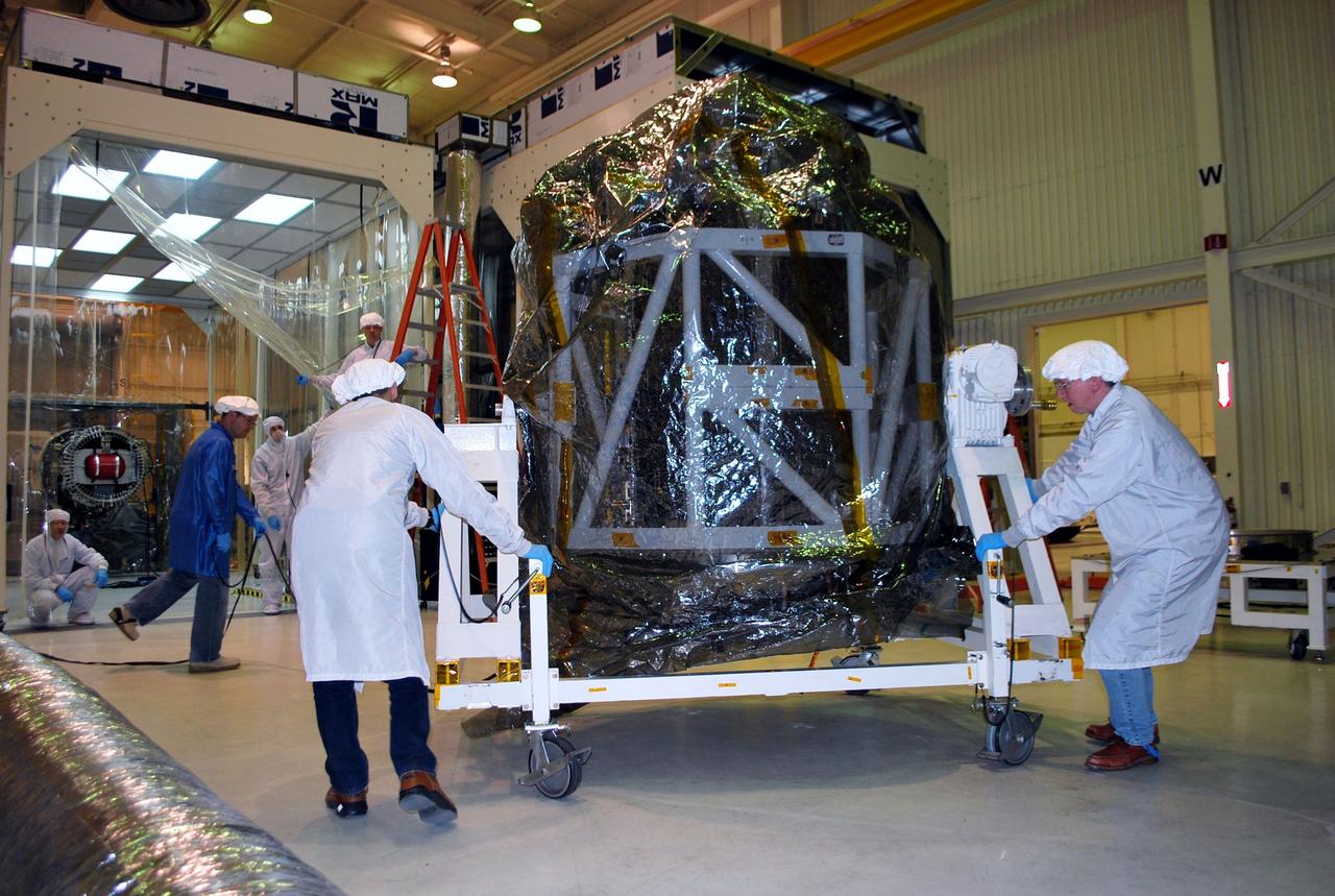 VANDENBERG AIR FORCE BASE, Calif. -- Now inside a tilt-rotation fixture and covered in protective plastic, NASA's NuSTAR spacecraft is prepared for joining with the Pegasus XL rocket inside Orbital Sciences' processing facility at Vandenberg Air Force Base, Calif. The Orbital Sciences Pegasus will launch NASA's Nuclear Spectroscopic Telescope Array NuSTAR into space. After the rocket and spacecraft are processed at Vandenberg, they will be flown on Orbital's L-1011 carrier aircraft to the Ronald Reagan Ballistic Missile Defense Test Site at the Pacific Ocean’s Kwajalein Atoll for launch. The high-energy x-ray telescope will conduct a census for black holes, map radioactive material in young supernovae remnants, and study the origins of cosmic rays and the extreme physics around collapsed stars. For more information, visit science.nasa.gov/missions/nustar/. Photo credit: NASA/Randy Beaudoin, VAFB