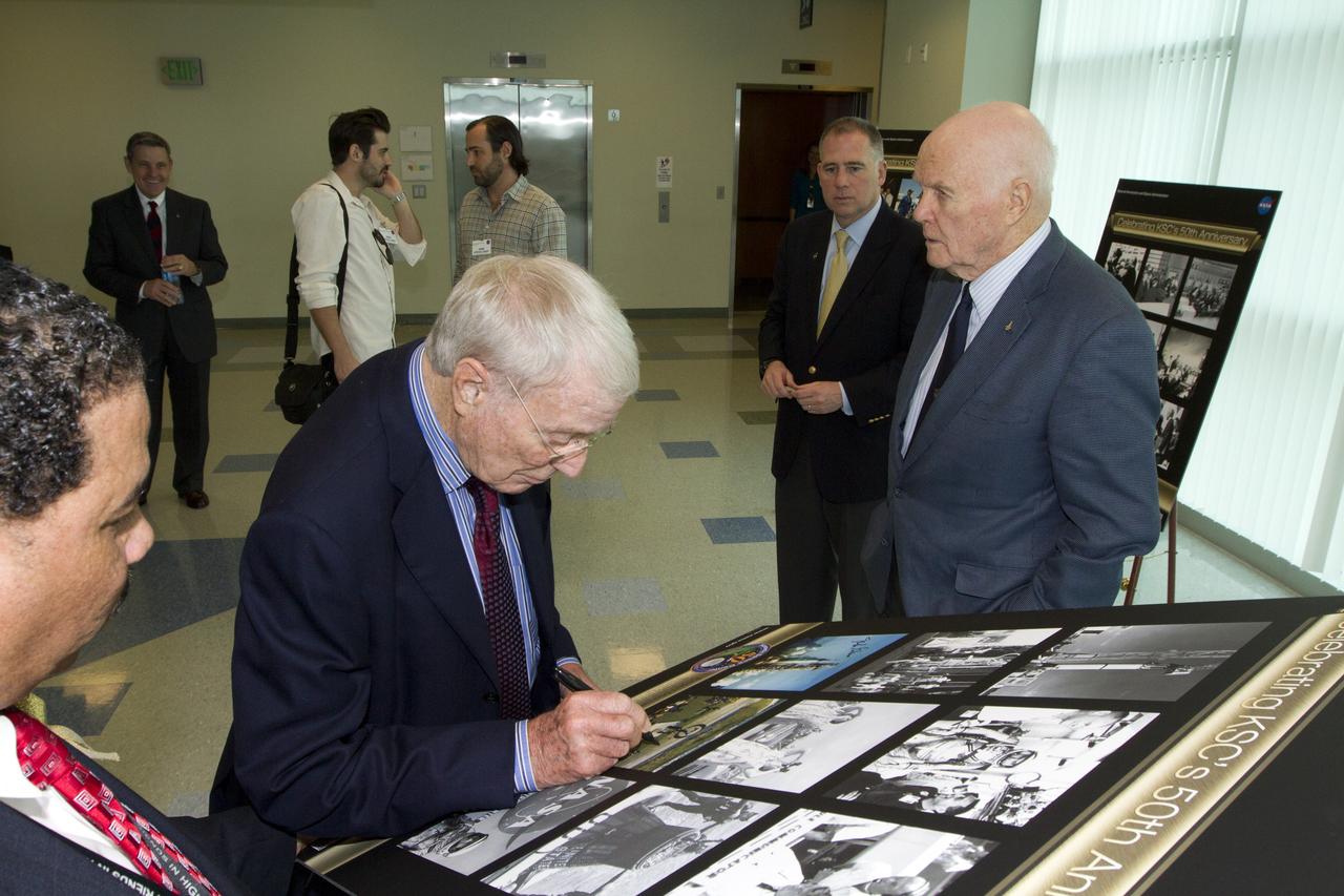 CAPE CANAVERAL, Fla. - Mercury astronaut Scott Carpenter signs a poster celebrating 50 years of Americans in orbit, an era which began with Glenn's Mercury mission MA-6, on Feb. 20, 1962.  Glenn's launch aboard an Atlas rocket took with it the hopes of an entire nation and ushered in a new era of space travel that eventually led to Americans walking on the moon by the end of the 1960s. Glenn soon was followed into orbit by Scott Carpenter, Walter Schirra and Gordon Cooper. Their fellow Mercury astronauts Alan Shepard and Virgil "Gus" Grissom flew earlier suborbital flights. Deke Slayton, a member of NASA's original Mercury 7 astronauts, was grounded by a medical condition until the Apollo-Soyuz Test Project in 1975. Photo credit: NASA/Kim Shiflett