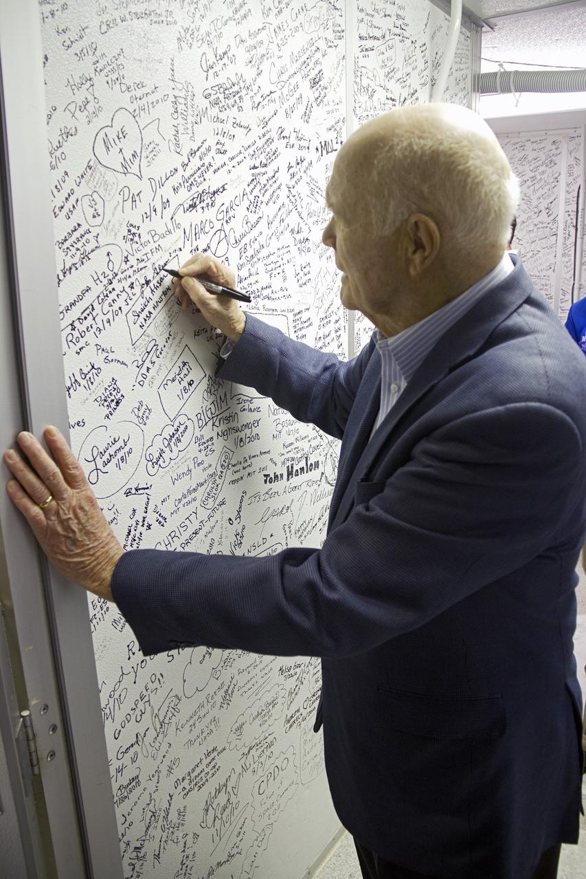 CAPE CANAVERAL, Fla. -- John Glenn signs the wall of the clean room leading into space shuttle Discovery in Orbiter Processing Facility-1 OPF-1 at NASA's Kennedy Space Center in Florida. Glenn is at the space center to mark the 50th anniversary of being the first American astronaut to orbit the Earth inside the NASA Mercury Project's Friendship 7 capsule on Feb. 20, 1962. Glenn later returned to space in October 1998 as a payload specialist aboard Discovery's STS-95 mission.      Glenn's launch aboard an Atlas rocket took with it the hopes of an entire nation and ushered in a new era of space travel that eventually led to Americans walking on the moon by the end of the 1960s. Glenn soon was followed into orbit by Scott Carpenter, Walter Schirra and Gordon Cooper. Their fellow Mercury astronauts Alan Shepard and Virgil "Gus" Grissom flew earlier suborbital flights. Deke Slayton, a member of NASA's original Mercury 7 astronauts, was grounded by a medical condition until the Apollo-Soyuz Test Project in 1975. Shuttle Discovery currently is being prepared for display at Smithsonian’s National Air and Space Museum, Steven F. Udvar-Hazy Center in Chantilly, Va. Photo credit: Cory Huston