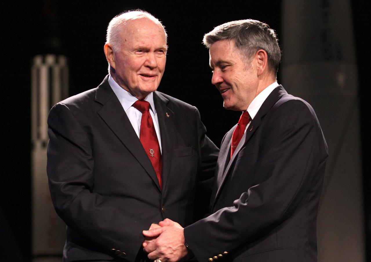 CAPE CANAVERAL, Fla. -- Mercury astronaut John Glenn, left, and Kennedy Space Center Director Bob Cabana shake hands following the "On Shoulders of Giants" program celebrating 50 years of Americans in orbit, an era which began with Glenn's MA-6 mission on Feb. 20, 1962. The event was conducted in the Rocket Garden at the Kennedy Space Center Visitor Complex in Florida a few miles from the launch pad where Glenn and Scott Carpenter took flight in Mercury spacecraft.  Glenn's launch aboard an Atlas rocket took with it the hopes of an entire nation and ushered in a new era of space travel that eventually led to Americans walking on the moon by the end of the 1960s. Glenn soon was followed into orbit by Scott Carpenter, Walter Schirra and Gordon Cooper. Their fellow Mercury astronauts Alan Shepard and Virgil "Gus" Grissom flew earlier suborbital flights. Deke Slayton, a member of NASA's original Mercury 7 astronauts, was grounded by a medical condition until the Apollo-Soyuz Test Project in 1975. Photo credit: Kim Shiflett