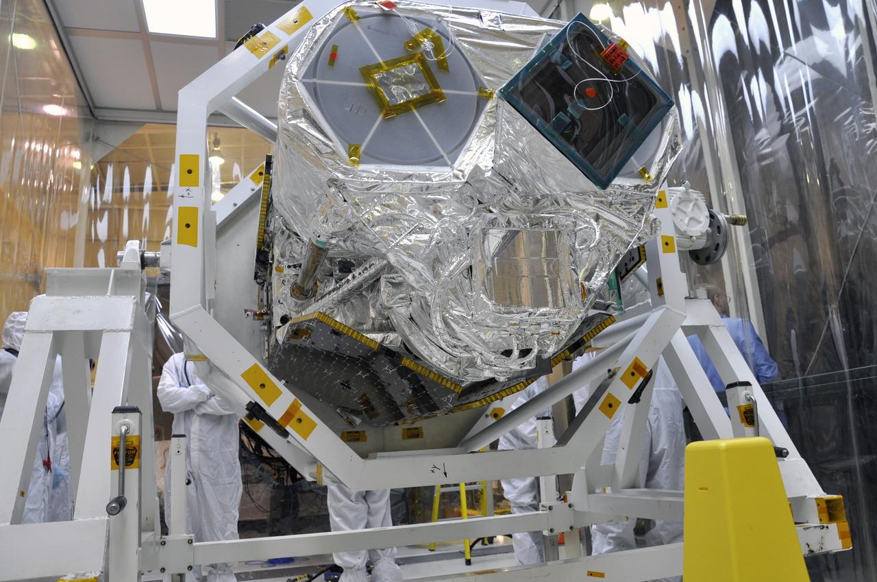 VANDENBERG AIR FORCE BASE, Calif. -- At Vandenberg Air Force Base's processing facility in California, the forward end of NASA's Nuclear Spectroscopic Telescope Array, or NuSTAR, spacecraft protrudes from the turnover rotation fixture used to rotate it into a horizontal position.  Preparations are under way to join NuSTAR with the Orbital Sciences Pegasus XL rocket that will launch it into space, a major milestone in launch preparations.          After processing of the rocket and spacecraft are complete, they will be flown on Orbital's L-1011 carrier aircraft from Vandenberg to the Ronald Reagan Ballistic Missile Defense Test Site on the Pacific Ocean’s Kwajalein Atoll for launch. The high-energy x-ray telescope will conduct a census of black holes, map radioactive material in young supernovae remnants, and study the origins of cosmic rays and the extreme physics around collapsed stars. For more information, visit http://www.nasa.gov/nustar.  Photo credit: NASA/Randy Beaudoin, VAFB