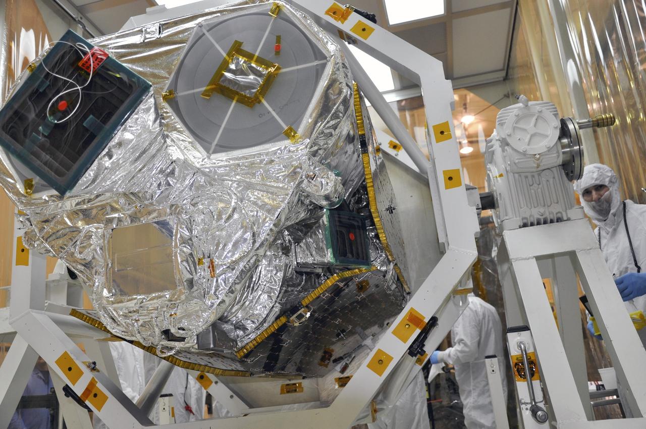 VANDENBERG AIR FORCE BASE, Calif. -- At Vandenberg Air Force Base's processing facility in California, the forward end of NASA's Nuclear Spectroscopic Telescope Array, or NuSTAR, spacecraft protrudes from the turnover rotation fixture used to rotate it into a horizontal position.  Technicians are preparing to join NuSTAR with the Orbital Sciences Pegasus XL rocket that will launch it into space, a major milestone in prelaunch preparations.         After processing of the rocket and spacecraft are complete, they will be flown on Orbital's L-1011 carrier aircraft from Vandenberg to the Ronald Reagan Ballistic Missile Defense Test Site on the Pacific Ocean’s Kwajalein Atoll for launch. The high-energy x-ray telescope will conduct a census of black holes, map radioactive material in young supernovae remnants, and study the origins of cosmic rays and the extreme physics around collapsed stars. For more information, visit http://www.nasa.gov/nustar.  Photo credit: NASA/Randy Beaudoin, VAFB
