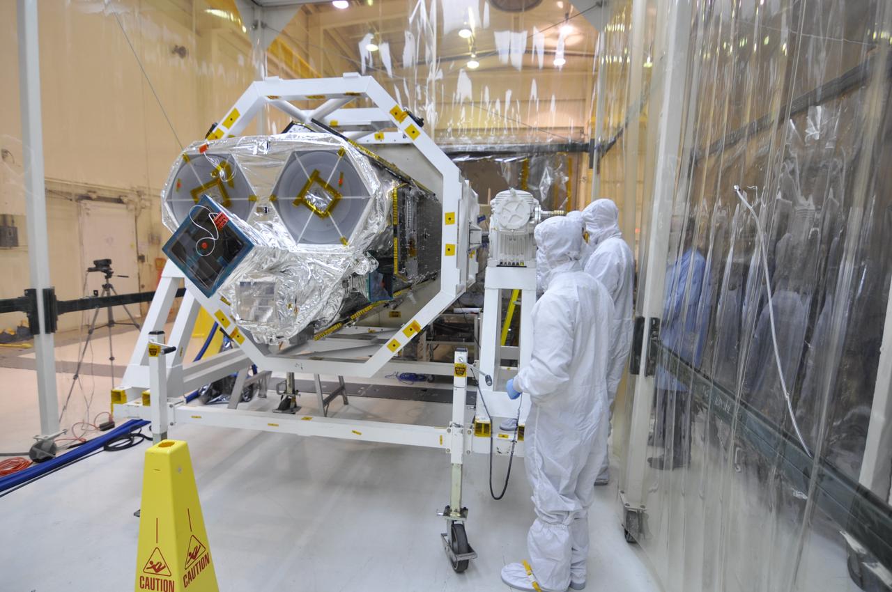 VANDENBERG AIR FORCE BASE, Calif. – Inside an environmental enclosure at Vandenberg Air Force Base's processing facility in California, technicians monitor NASA's Nuclear Spectroscopic Telescope Array, or NuSTAR, secured inside a turnover rotation fixture, as it moves toward interface with its Orbital Sciences Pegasus XL rocket.  The technicians are dressed in clean room attire, known as bunny suits.  The conjoining of the spacecraft with the rocket is a major milestone in prelaunch preparations.        After processing of the rocket and spacecraft are complete, they will be flown on Orbital's L-1011 carrier aircraft from Vandenberg to the Ronald Reagan Ballistic Missile Defense Test Site on the Pacific Ocean’s Kwajalein Atoll for launch. The high-energy x-ray telescope will conduct a census of black holes, map radioactive material in young supernovae remnants, and study the origins of cosmic rays and the extreme physics around collapsed stars. For more information, visit http://www.nasa.gov/nustar.  Photo credit: NASA/Randy Beaudoin, VAFB
