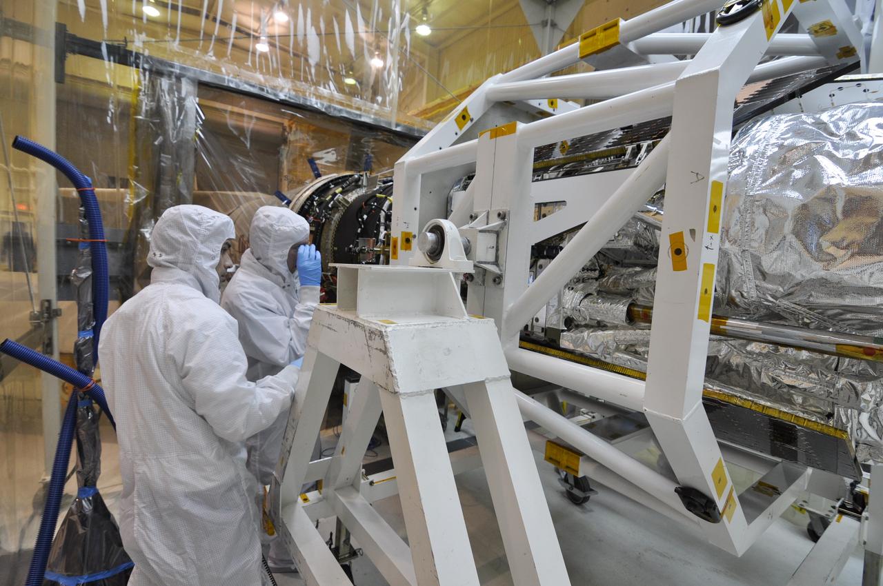 VANDENBERG AIR FORCE BASE, Calif. – Inside an environmental enclosure at Vandenberg Air Force Base's processing facility in California, technicians check the interface of NASA's Nuclear Spectroscopic Telescope Array, or NuSTAR, with its Orbital Sciences Pegasus XL rocket. The spacecraft is secured inside the turnover rotation fixture used to rotate it into a horizontal position. The uniting of the spacecraft with the rocket is a major milestone in prelaunch preparations. After processing of the rocket and spacecraft are complete, they will be flown on Orbital's L-1011 carrier aircraft from Vandenberg to the Ronald Reagan Ballistic Missile Defense Test Site on the Pacific Ocean’s Kwajalein Atoll for launch. The high-energy x-ray telescope will conduct a census of black holes, map radioactive material in young supernovae remnants, and study the origins of cosmic rays and the extreme physics around collapsed stars. For more information, visit http://www.nasa.gov/nustar. Photo credit: NASA/Randy Beaudoin, VAFB