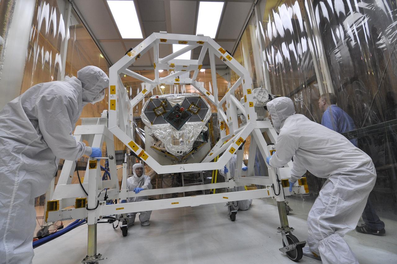 VANDENBERG AIR FORCE BASE, Calif. – Inside an environmental enclosure at Vandenberg Air Force Base's processing facility in California, technicians roll the turnover rotation fixture away from NASA's Nuclear Spectroscopic Telescope Array, or NuSTAR, following its mating to an Orbital Sciences Pegasus XL rocket. The turnover rotation fixture was used to rotate the spacecraft into a horizontal position and supported it during mating operations. The uniting of the spacecraft with the rocket is a major milestone in prelaunch preparations. After processing of the rocket and spacecraft are complete, they will be flown on Orbital's L-1011 carrier aircraft from Vandenberg to the Ronald Reagan Ballistic Missile Defense Test Site on the Pacific Ocean’s Kwajalein Atoll for launch. The high-energy x-ray telescope will conduct a census of black holes, map radioactive material in young supernovae remnants, and study the origins of cosmic rays and the extreme physics around collapsed stars. For more information, visit http://www.nasa.gov/nustar. Photo credit: NASA/Randy Beaudoin, VAFB