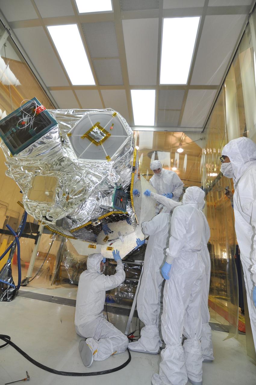 VANDENBERG AIR FORCE BASE, Calif. – Inside an environmental enclosure at Vandenberg Air Force Base's processing facility in California, technicians remove a section of the C-plate from the interface of NASA's Nuclear Spectroscopic Telescope Array, or NuSTAR, spacecraft and its Orbital Sciences Pegasus XL rocket. The C-plate protected the spacecraft during mating operations. The uniting of the spacecraft with the rocket is a major milestone in prelaunch preparations. After processing of the rocket and spacecraft are complete, they will be flown on Orbital's L-1011 carrier aircraft from Vandenberg to the Ronald Reagan Ballistic Missile Defense Test Site on the Pacific Ocean’s Kwajalein Atoll for launch. The high-energy x-ray telescope will conduct a census of black holes, map radioactive material in young supernovae remnants, and study the origins of cosmic rays and the extreme physics around collapsed stars. For more information, visit http://www.nasa.gov/nustar. Photo credit: NASA/Randy Beaudoin, VAFB