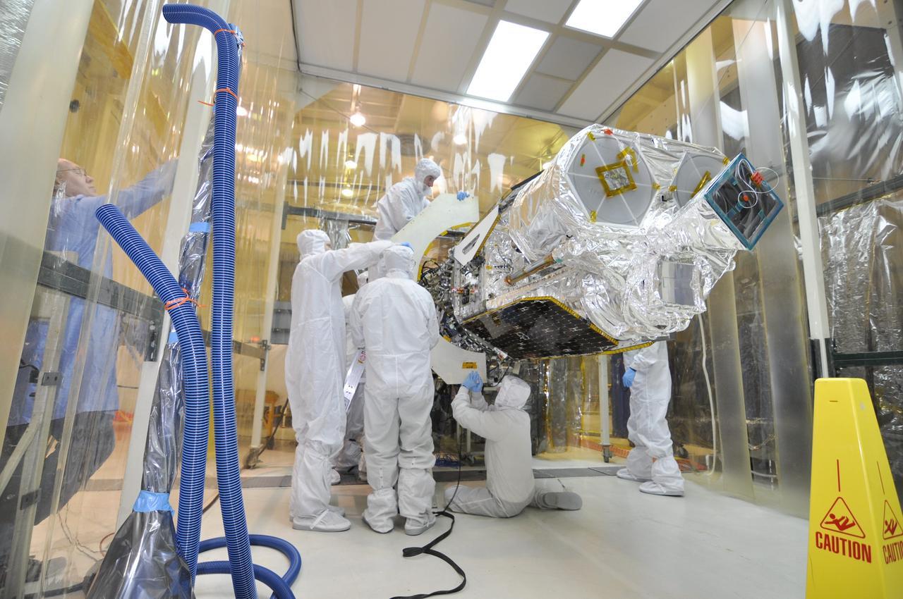 VANDENBERG AIR FORCE BASE, Calif. – Inside an environmental enclosure at Vandenberg Air Force Base's processing facility in California, technicians remove the remaining half of the C-plate from the point of interface of NASA's Nuclear Spectroscopic Telescope Array, or NuSTAR, spacecraft and its Orbital Sciences Pegasus XL rocket. The C-plate protected the spacecraft during mating operations. The uniting of the spacecraft with the rocket is a major milestone in prelaunch preparations. After processing of the rocket and spacecraft are complete, they will be flown on Orbital's L-1011 carrier aircraft from Vandenberg to the Ronald Reagan Ballistic Missile Defense Test Site on the Pacific Ocean’s Kwajalein Atoll for launch. The high-energy x-ray telescope will conduct a census of black holes, map radioactive material in young supernovae remnants, and study the origins of cosmic rays and the extreme physics around collapsed stars. For more information, visit http://www.nasa.gov/nustar. Photo credit: NASA/Randy Beaudoin, VAFB