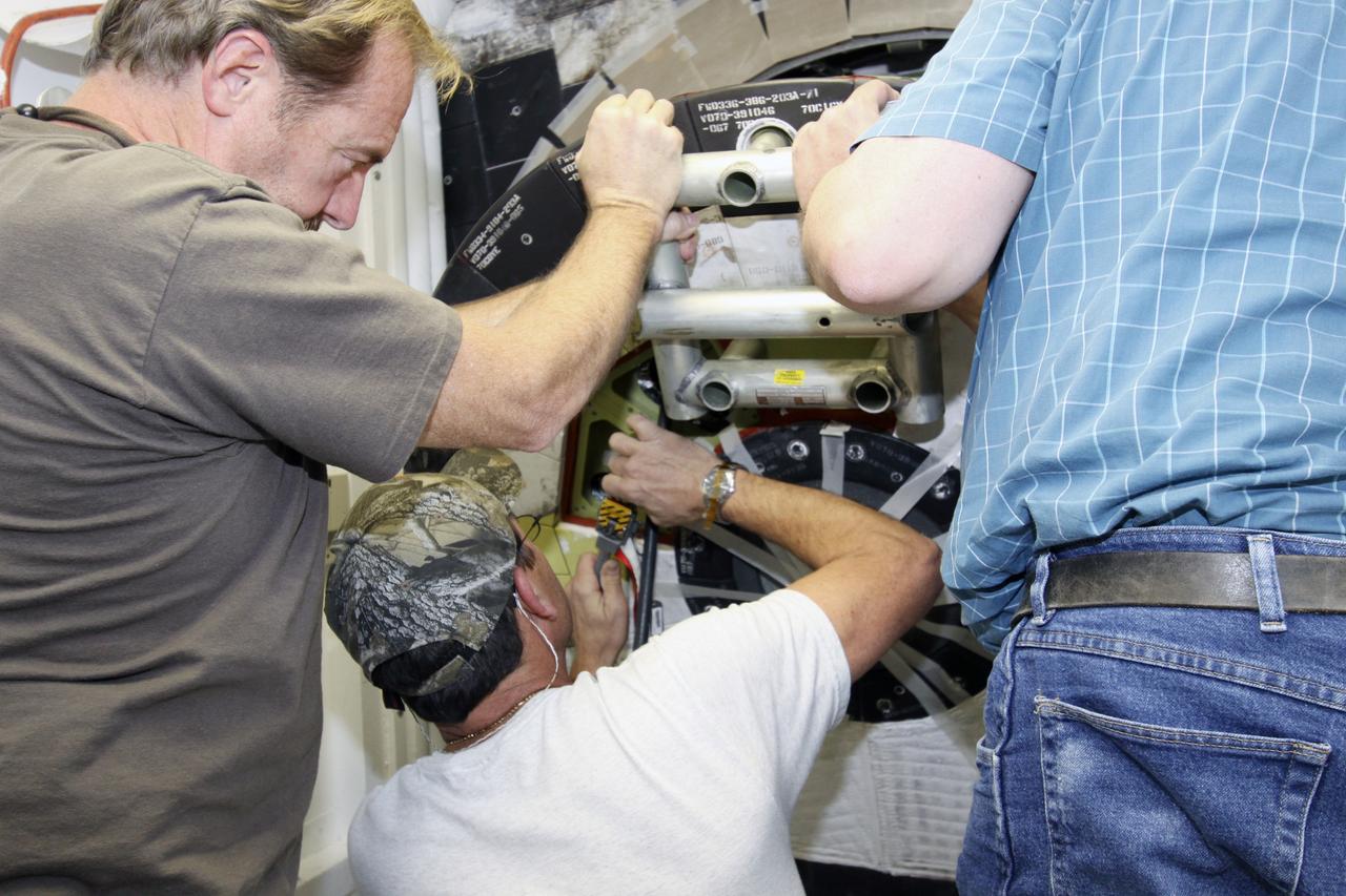 CAPE CANAVERAL, Fla. -- Inside Orbiter Processing Facility-1 at NASA’s Kennedy Space Center in Florida, technicians position space shuttle Discovery’s access hatch for final close out.     The work is part of the Space Shuttle Program’s transition and retirement processing of shuttle Discovery, which is being prepared for display at Smithsonian’s National Air and Space Museum, Steven F. Udvar-Hazy Center in Chantilly, Va. Discovery is scheduled to be transported atop a NASA Shuttle Carrier Aircraft modified 747 jet to Dulles International Airport in Virginia on April 17 and then be transported to the Smithsonian on April 19. For more information, visit http://www.nasa.gov/shuttle.  Photo credit: NASA/Jim Grossmann