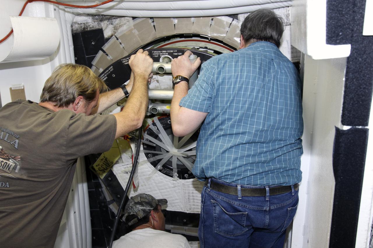 CAPE CANAVERAL, Fla. -- Inside Orbiter Processing Facility-1 at NASA’s Kennedy Space Center in Florida, technicians position space shuttle Discovery’s access hatch for final close out.     The work is part of the Space Shuttle Program’s transition and retirement processing of shuttle Discovery, which is being prepared for display at Smithsonian’s National Air and Space Museum, Steven F. Udvar-Hazy Center in Chantilly, Va. Discovery is scheduled to be transported atop a NASA Shuttle Carrier Aircraft modified 747 jet to Dulles International Airport in Virginia on April 17 and then be transported to the Smithsonian on April 19. For more information, visit http://www.nasa.gov/shuttle.  Photo credit: NASA/Jim Grossmann