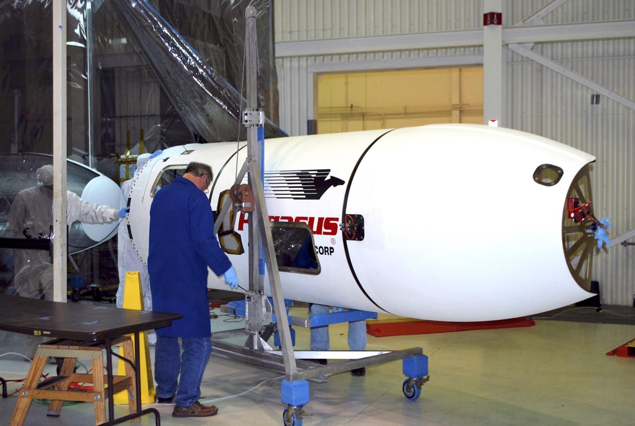 VANDENBERG AIR FORCE BASE, Calif. – A technician rolls a section of the fairing for NASA's Nuclear Spectroscopic Telescope Array, or NuSTAR, out of an environmental enclosure inside the Orbital Sciences processing facility at Vandenberg Air Force Base in California toward the facility’s clean room.    The fairing will enclose and protect the spacecraft from the heat and aerodynamic pressure generated during ascent to orbit aboard an Orbital Sciences Pegasus XL rocket.  After processing of the rocket and spacecraft are complete, they will be flown on Orbital's L-1011 carrier aircraft from Vandenberg to the Ronald Reagan Ballistic Missile Defense Test Site on the Pacific Ocean’s Kwajalein Atoll for launch in March. The high-energy x-ray telescope will conduct a census of black holes, map radioactive material in young supernovae remnants, and study the origins of cosmic rays and the extreme physics around collapsed stars. For more information, visit http://www.nasa.gov/nustar.  Photo credit: NASA/Randy Beaudoin, VAFB