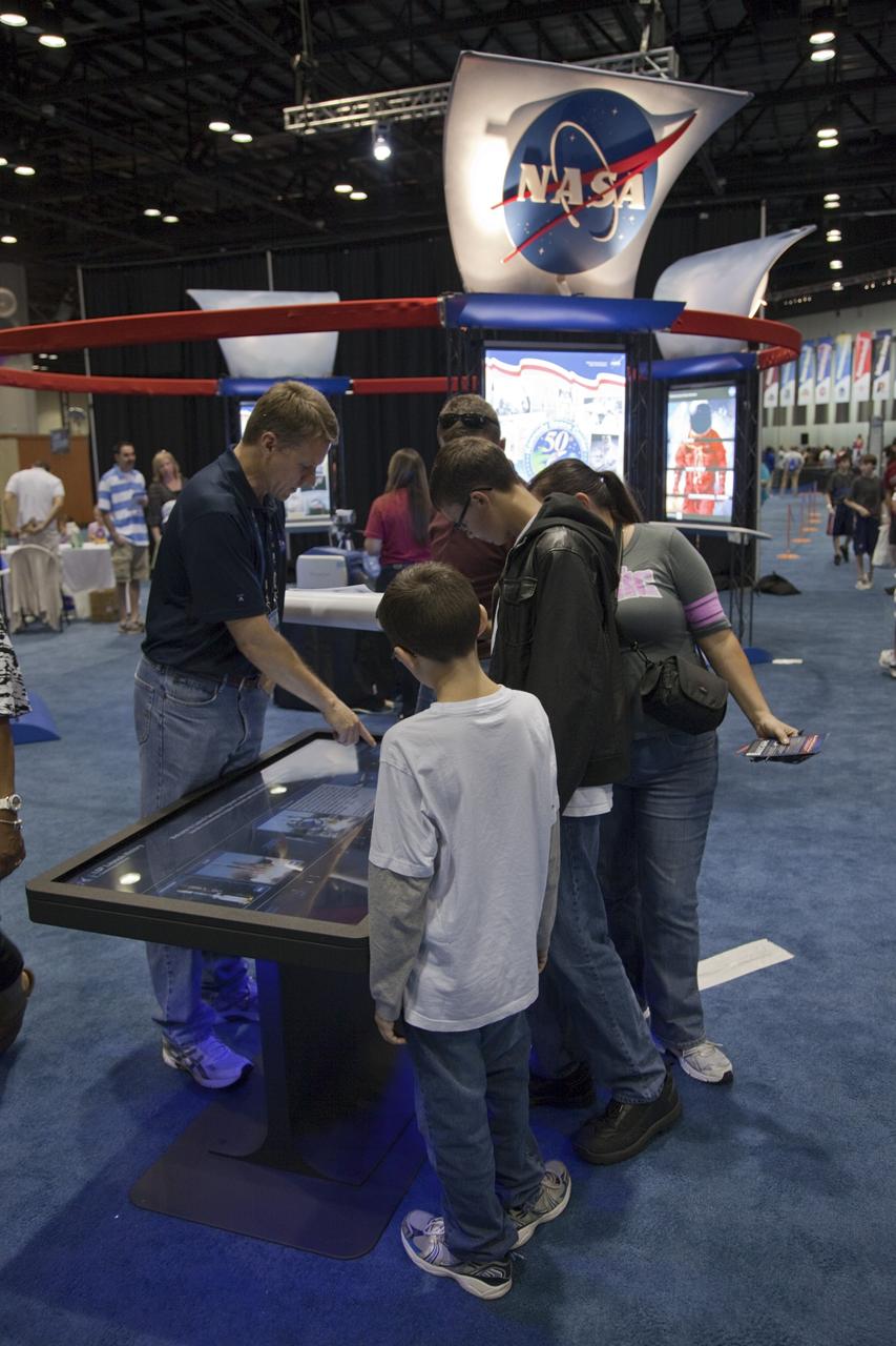 ORLANDO, Fla. -- Visitors to the NBA All-Star Jam Session at the Orange County Convention Center in Orlando, Fla., use a large touch-screen to learn more about NASA's activities and missions. Representatives from Kennedy Space Center in Florida helped attendees participate in hands-on educational activities to learn more about how science plays into sports.     One of the events leading up to the NBA All-Star game being held in Orlando on Feb. 26, the NBA All-Star Jam Session is a basketball experience intended for all ages, allowing fans to compete against their friends in skills challenges and collect autographs from players and legends. Photo credit: NASA/Frankie Martin