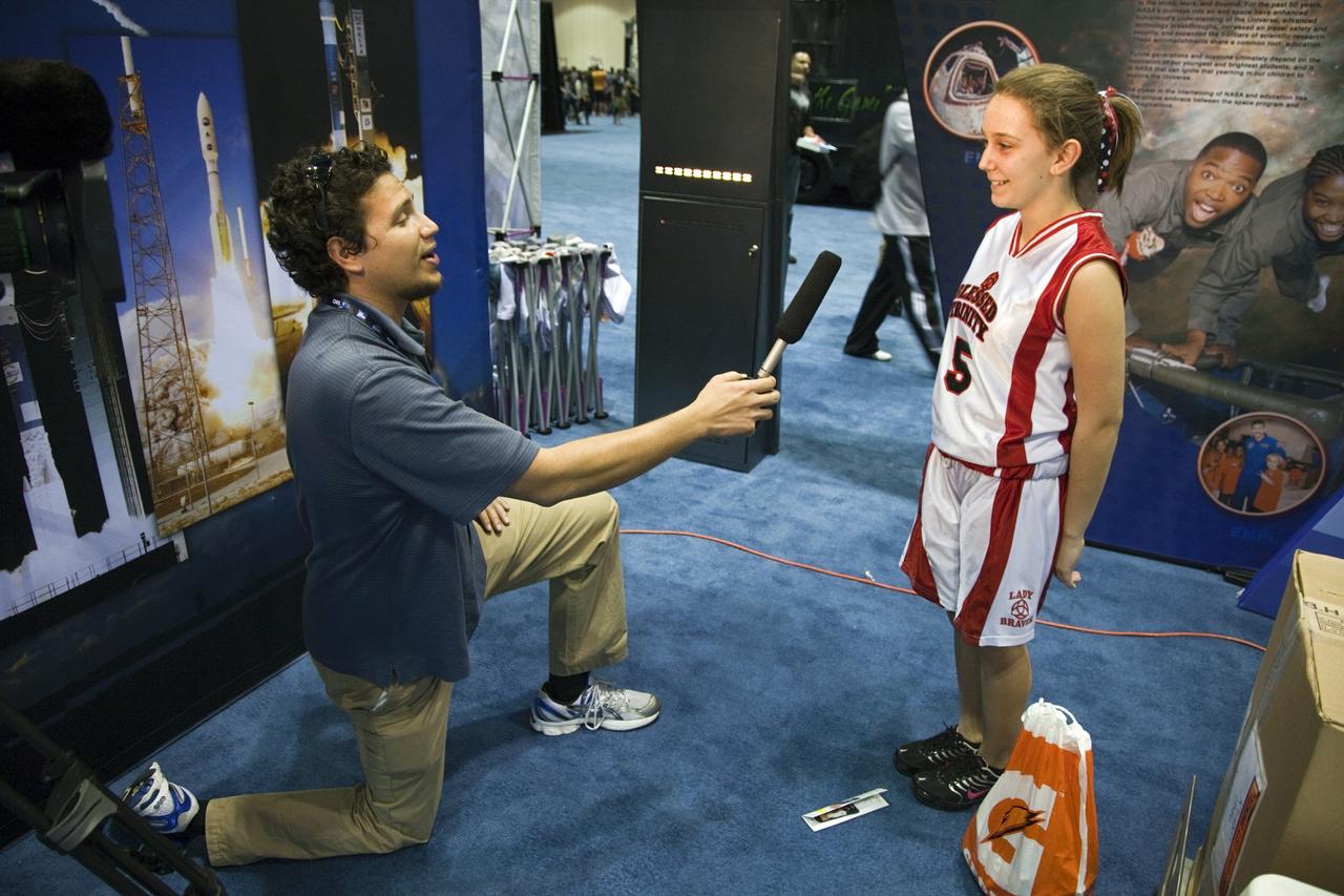 ORLANDO, Fla. -- A representative from NASA's Kennedy Space Center in Florida speaks with a young visitor attending the NBA All-Star Jam Session at the Orange County Convention Center in Orlando, Fla. The NASA exhibit offers hands-on educational activities highlighting some of the contributions the space agency has made to sports, transportation and everyday life.     One of the events leading up to the NBA All-Star game being held in Orlando on Feb. 26, the NBA All-Star Jam Session is a basketball experience intended for all ages, allowing fans to compete against their friends in skills challenges and collect autographs from players and legends. Photo credit: NASA/Frankie Martin