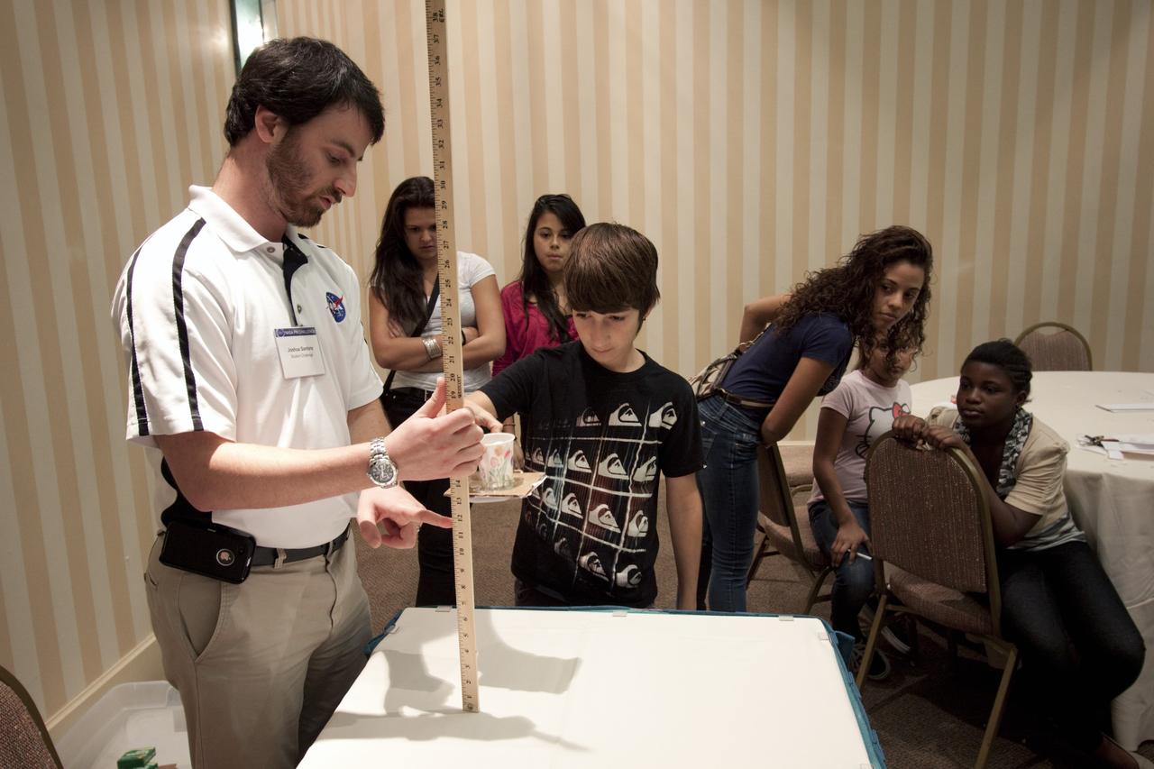 ORLANDO, Fla. – Education project specialist Josh Santora, left, from NASA’s Kennedy Space Center, engages a student from Meadow Woods Middle School in Orlando in a physics demonstration during NASA’s Project Management PM Challenge 2012.    The demonstrations are designed to increase student interest and pursuit of the science, technology, engineering and mathematics STEM fields integral to producing the next generation of scientists and engineers. PM Challenge 2012 was held at the Caribe Royale Hotel and Convention Center in Orlando, Fla., on Feb. 22-23, to provide a forum for all stakeholders in the project management community to meet and share stories, lessons learned and new uses of technology in the industry. The PM Challenge is sponsored by NASA's Office of the Chief Engineer. For additional information, visit http://www.nasa.gov/offices/oce/pmchallenge/index.html.  Photo credit: NASA/Jim Grossmann