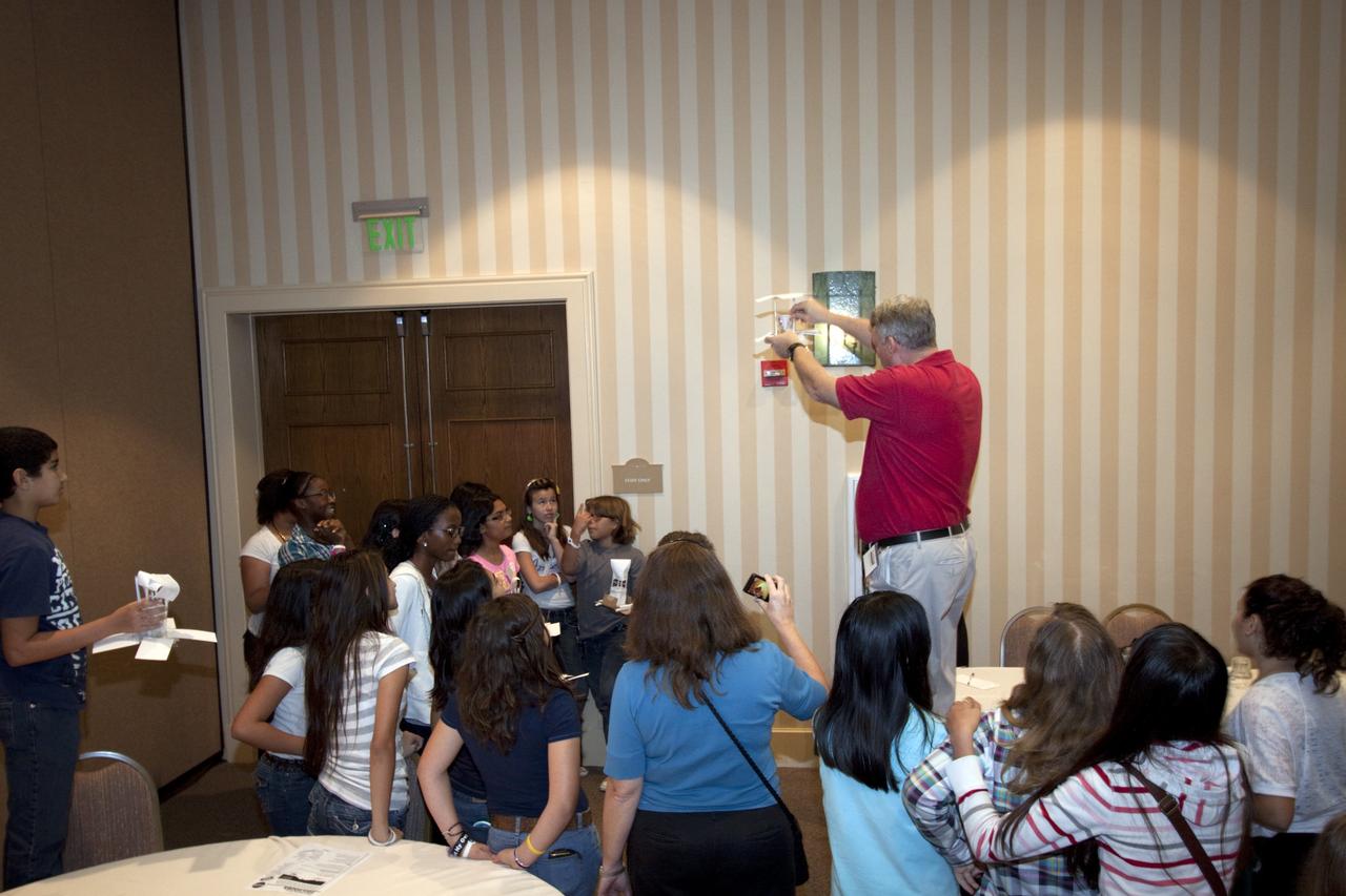 ORLANDO, Fla. – Education specialist Jim Gerard, in the red shirt, from NASA’s Kennedy Space Center, prepares a physics demonstration for students from Meadow Woods Middle School in Orlando during NASA’s Project Management PM Challenge 2012.    The demonstrations are designed to increase student interest and pursuit of the science, technology, engineering and mathematics STEM fields integral to producing the next generation of scientists and engineers. PM Challenge 2012 was held at the Caribe Royale Hotel and Convention Center in Orlando, Fla., on Feb. 22-23, to provide a forum for all stakeholders in the project management community to meet and share stories, lessons learned and new uses of technology in the industry. The PM Challenge is sponsored by NASA's Office of the Chief Engineer. For additional information, visit http://www.nasa.gov/offices/oce/pmchallenge/index.html.  Photo credit: NASA/Jim Grossmann